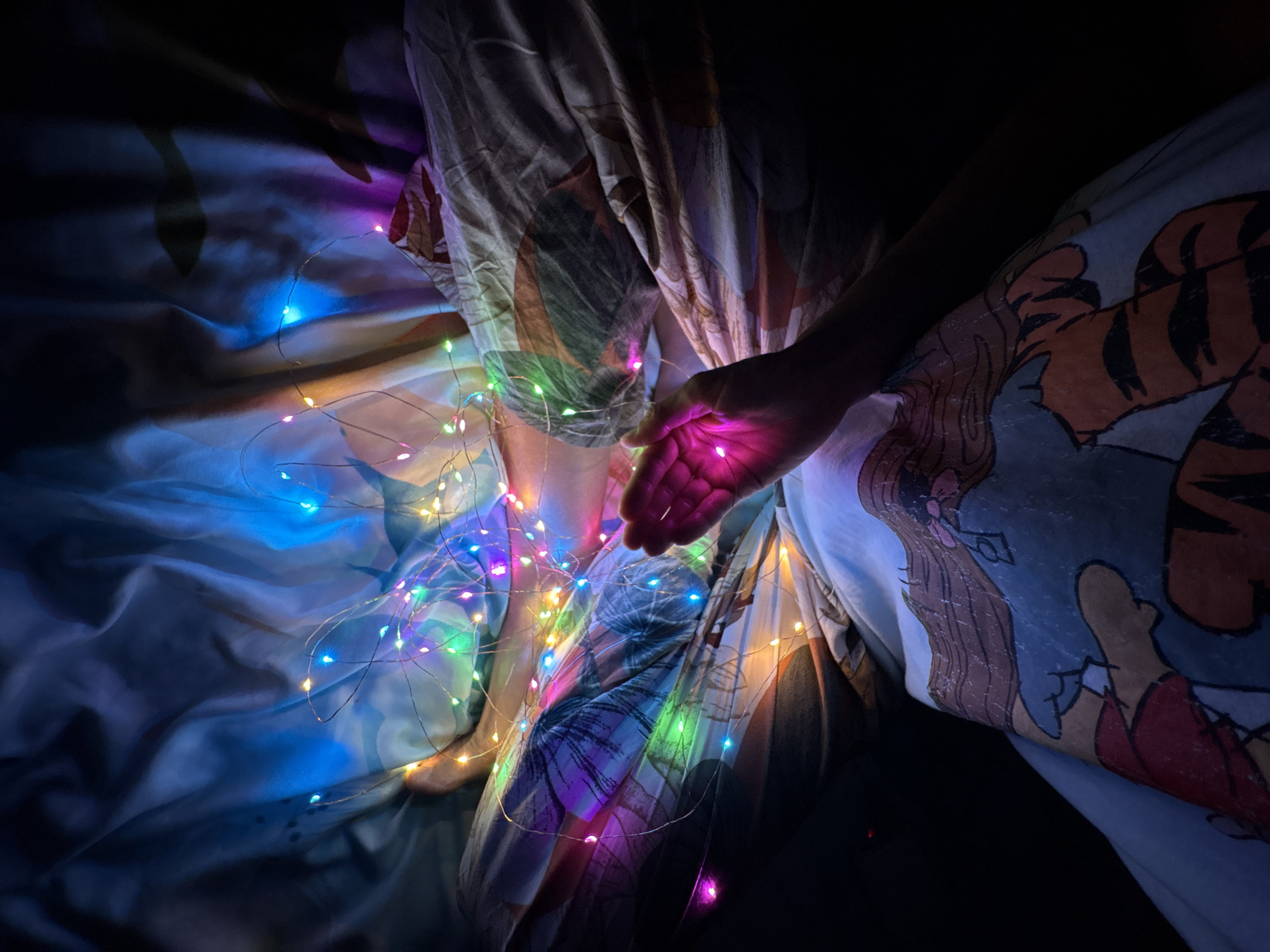 Person in bed with fairy lights in Ulyanovsk
