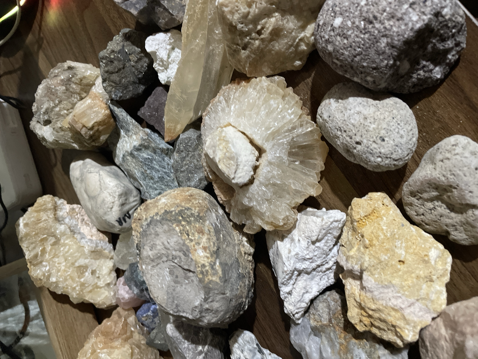 Rock collector displays mineral specimens on wooden surface in Davao