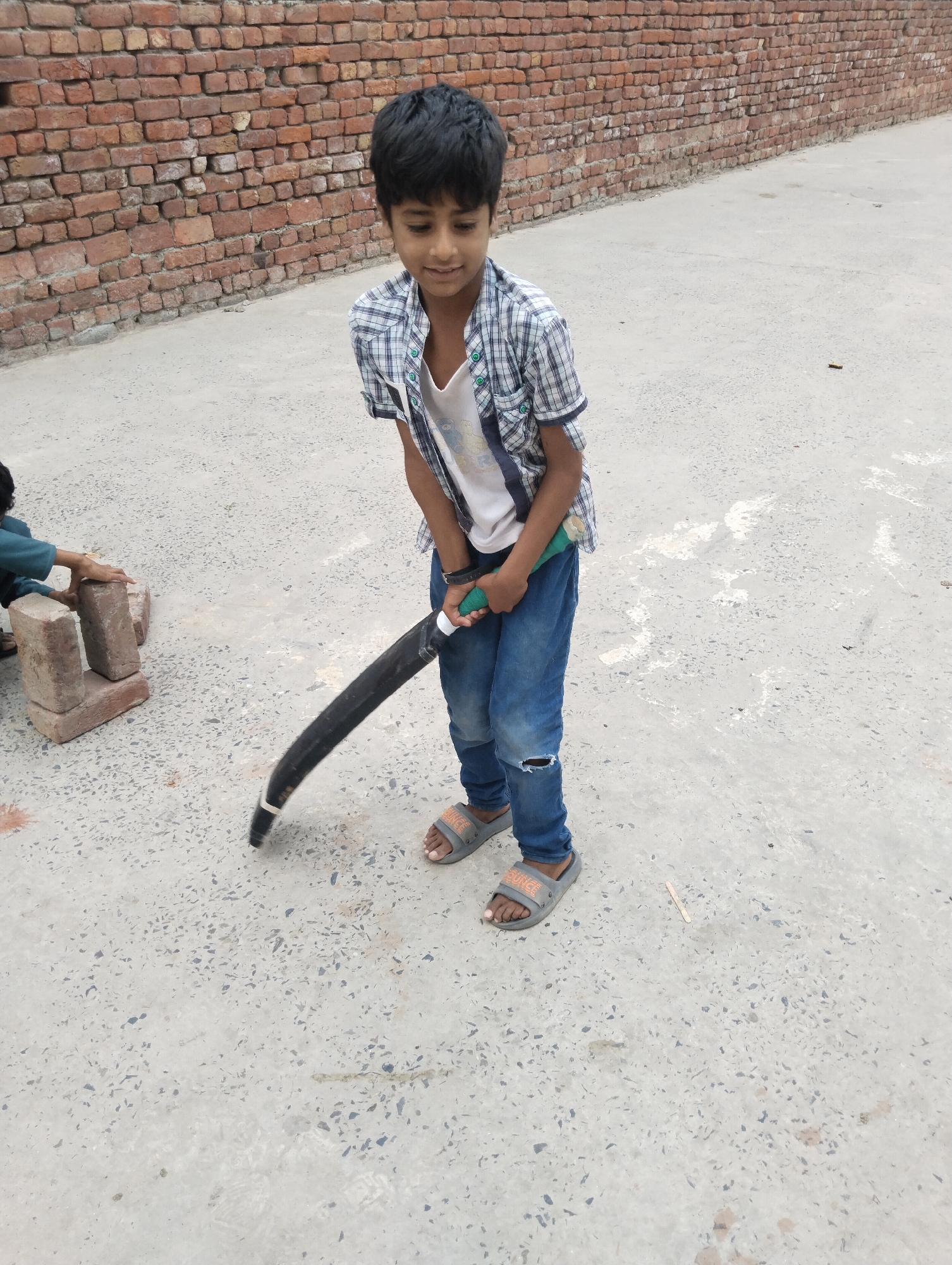 Boys handle bricks in early morning activity in Dera Chahal