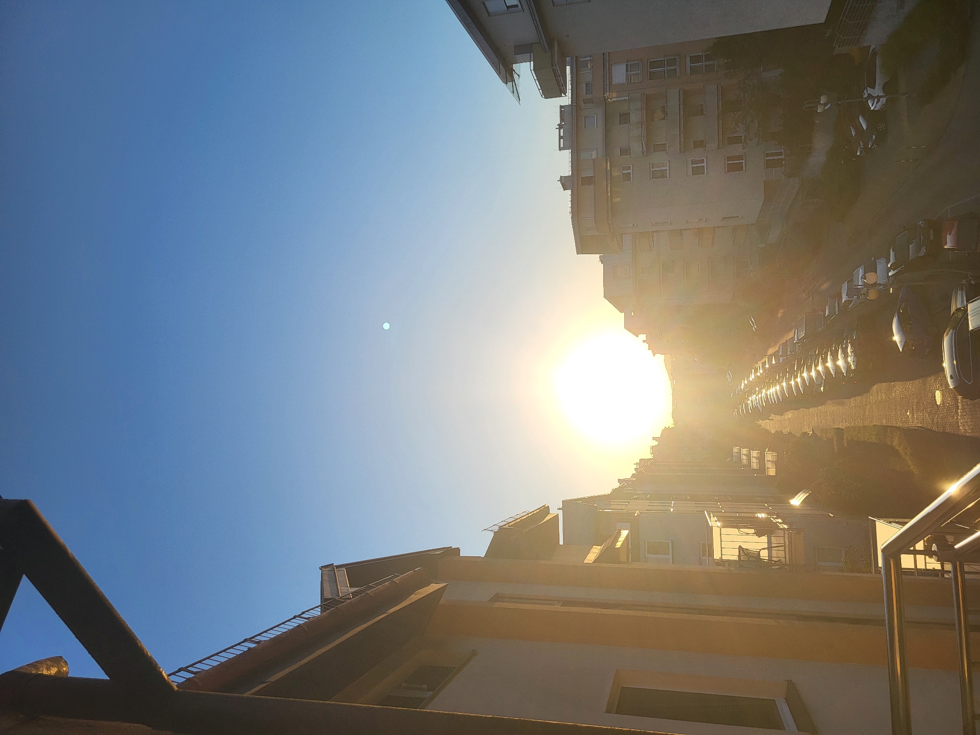 Golden-hour sun over a city street, lens flare and all