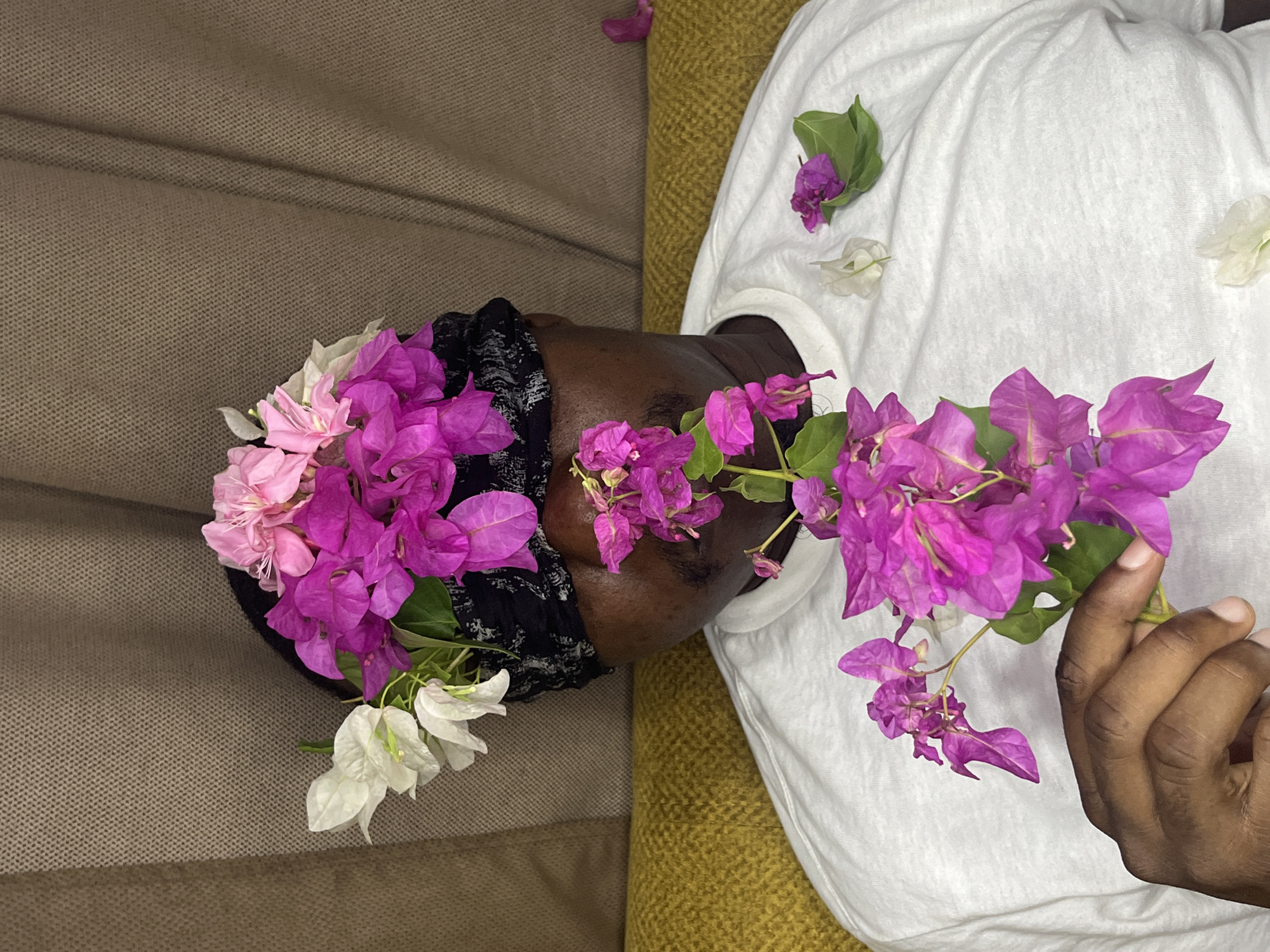 Person photographed resting with flowers in Accra artistic portrait session