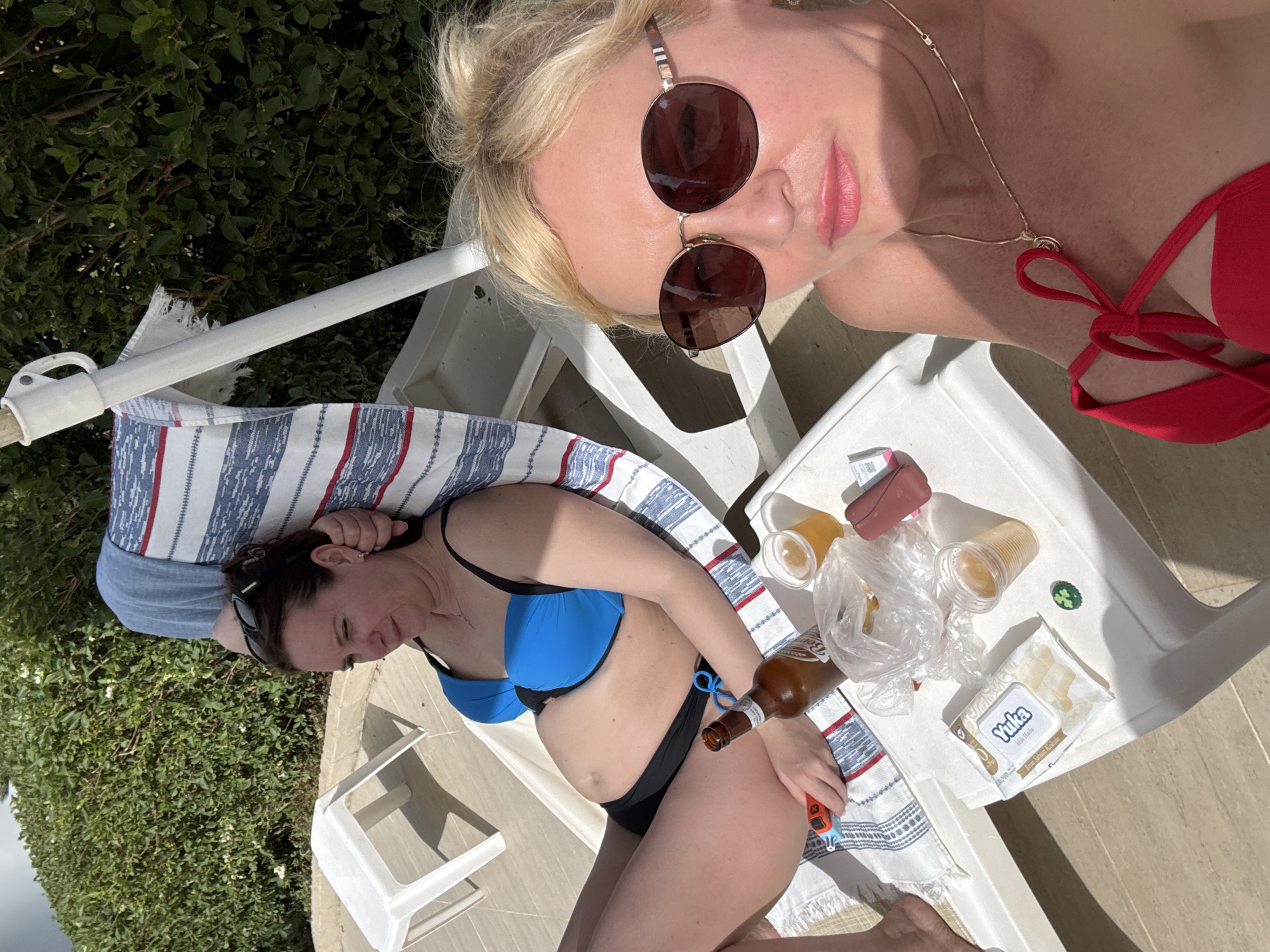 Women relax poolside on sunny afternoon