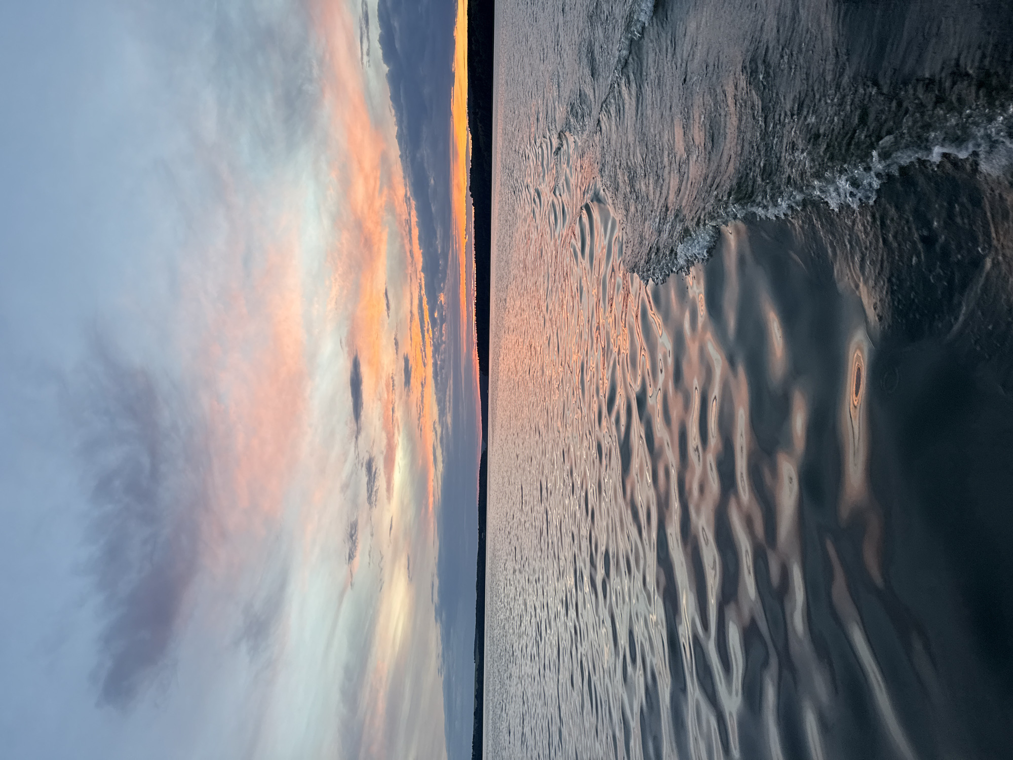Boat wake and a vivid sunset over a Votkinsk lake
