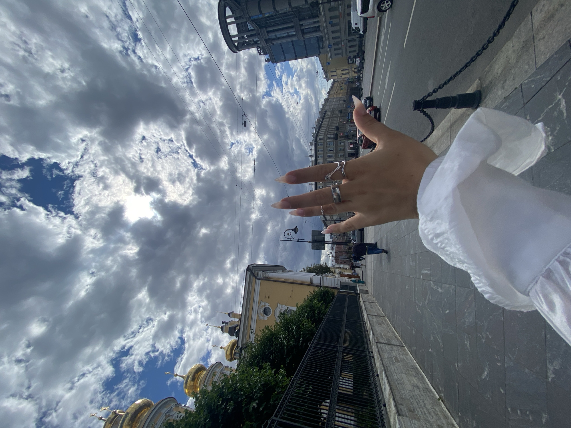 Selfie session on a Saint Petersburg sidewalk, summer morning