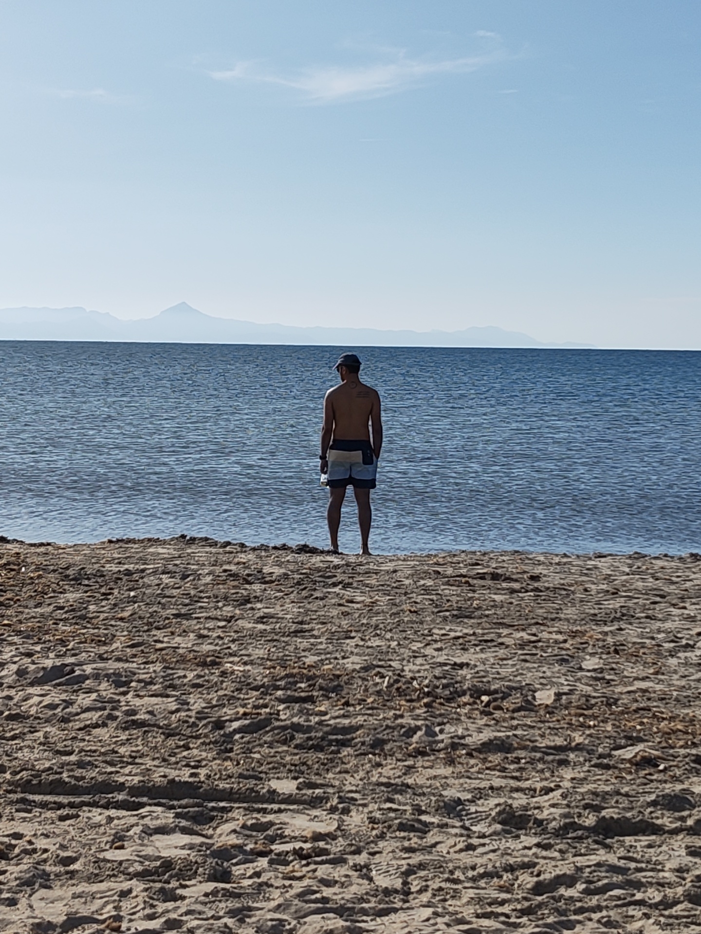 Man contemplates sea at Dénia beach on clear day