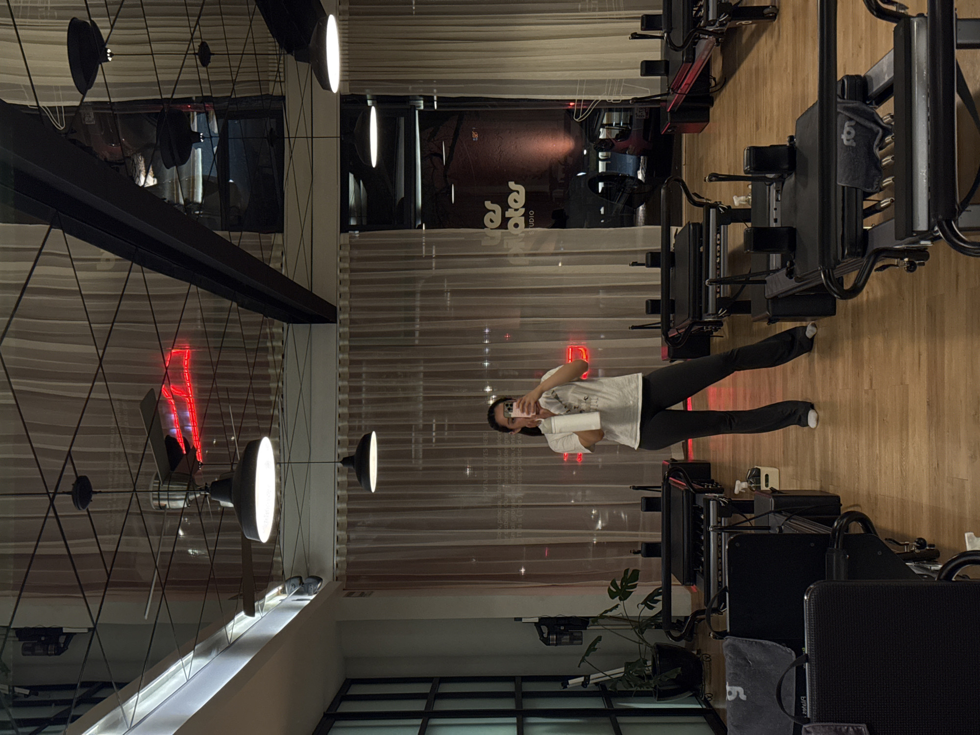 Woman documents evening Pilates workout session in Puebla studio