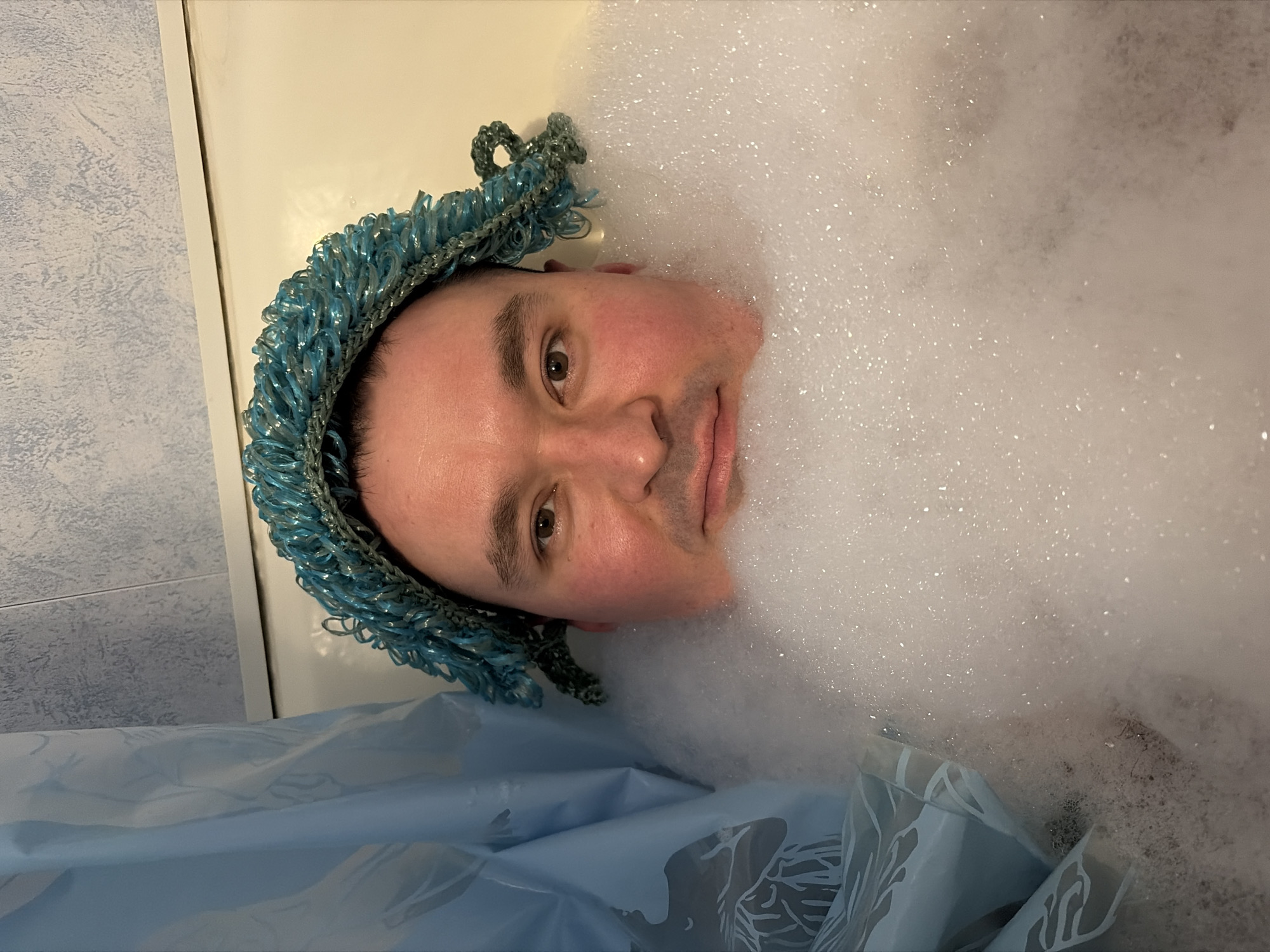 Man Takes Playful Bubble Bath Wearing Swimming Goggles in Izhevsk