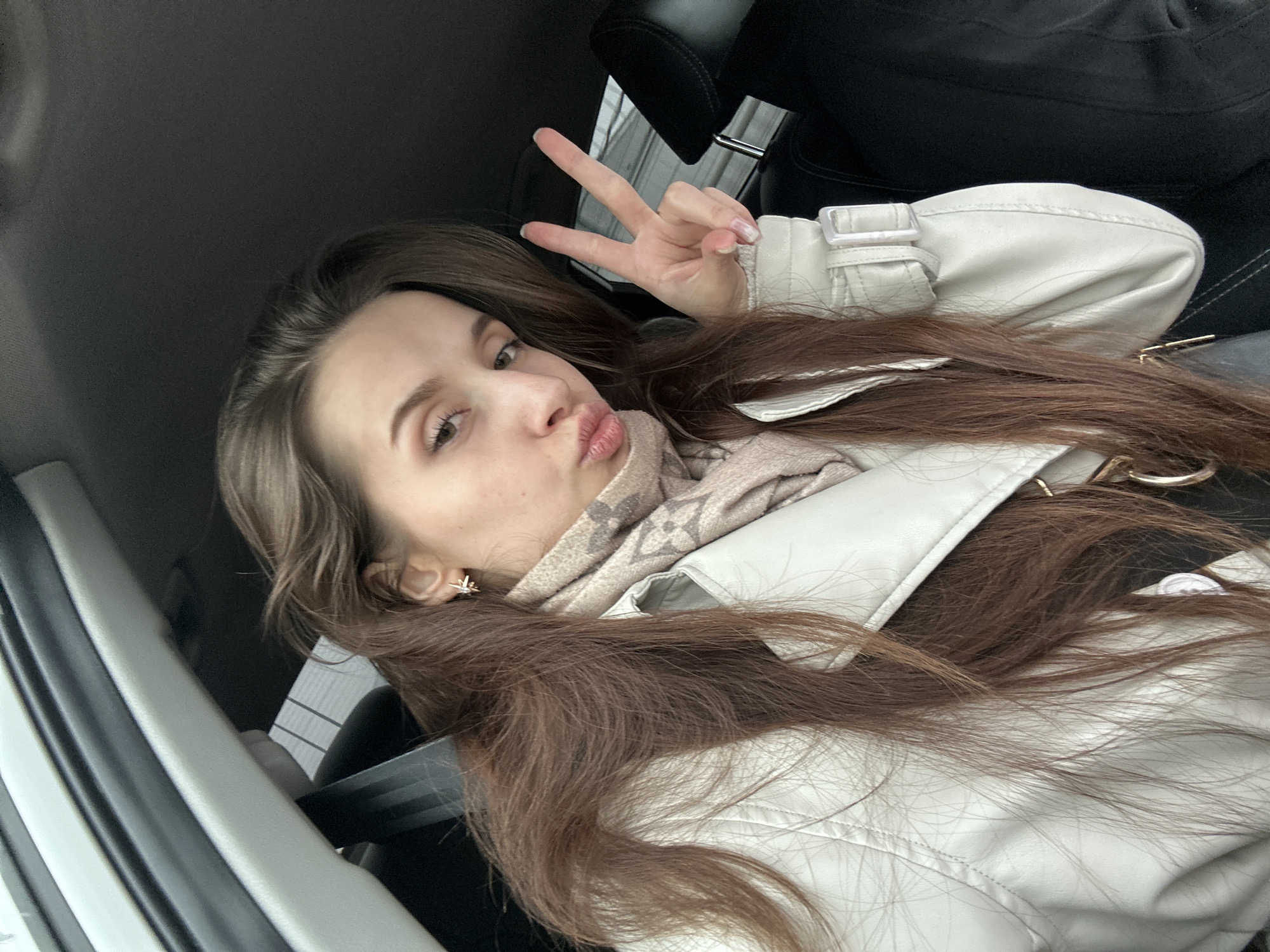 Woman makes peace sign gesture in vehicle in Chaikovsky