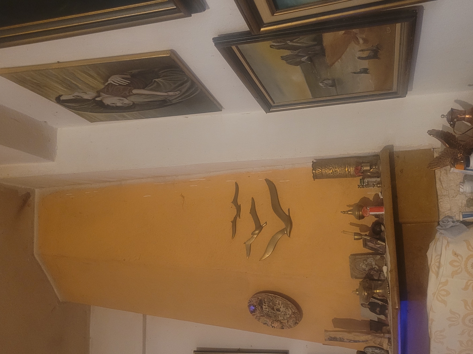 Living room decorated with metal bird sculptures on orange wall