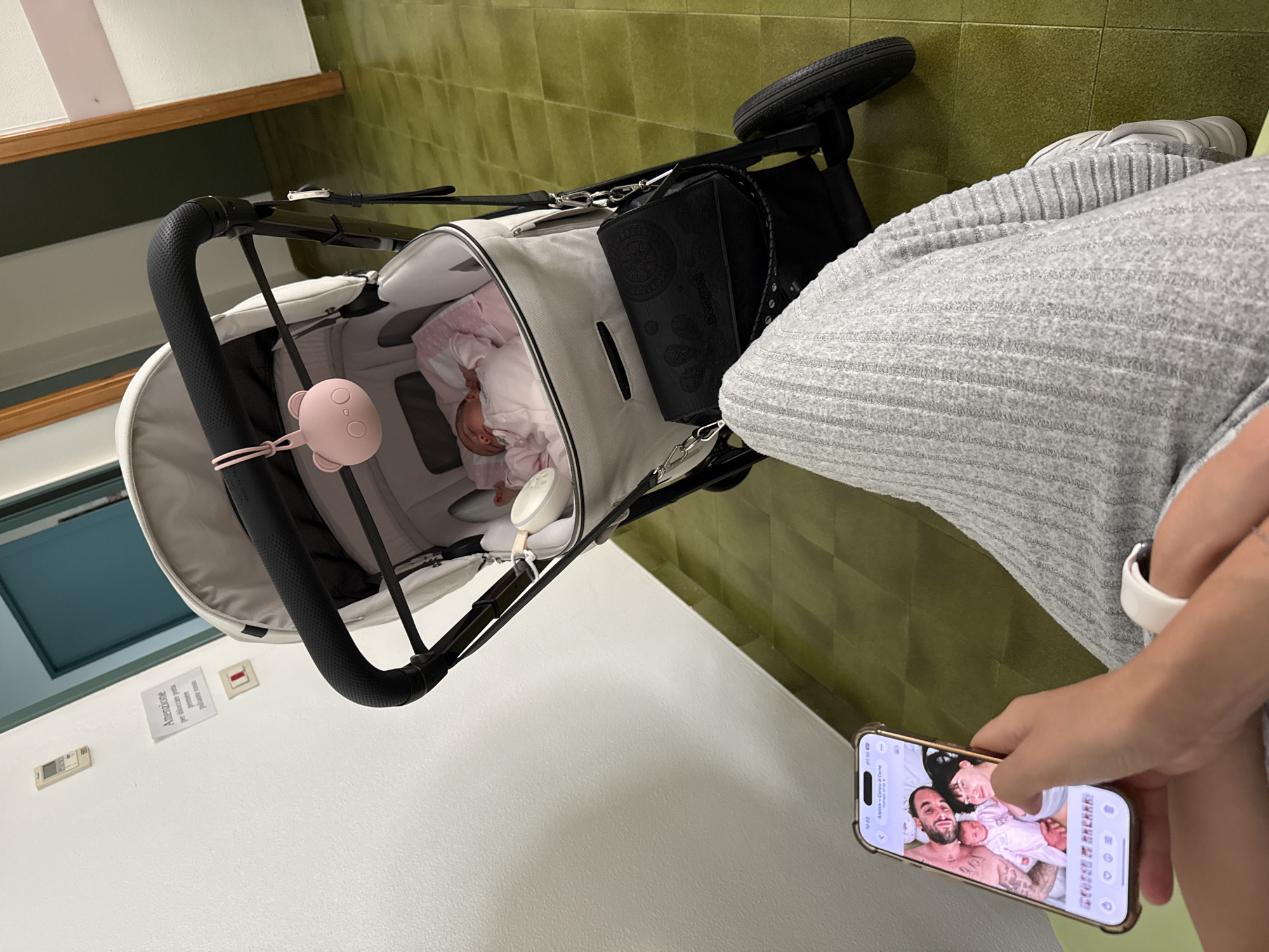 Mother views family photos while caring for baby in Aprilia