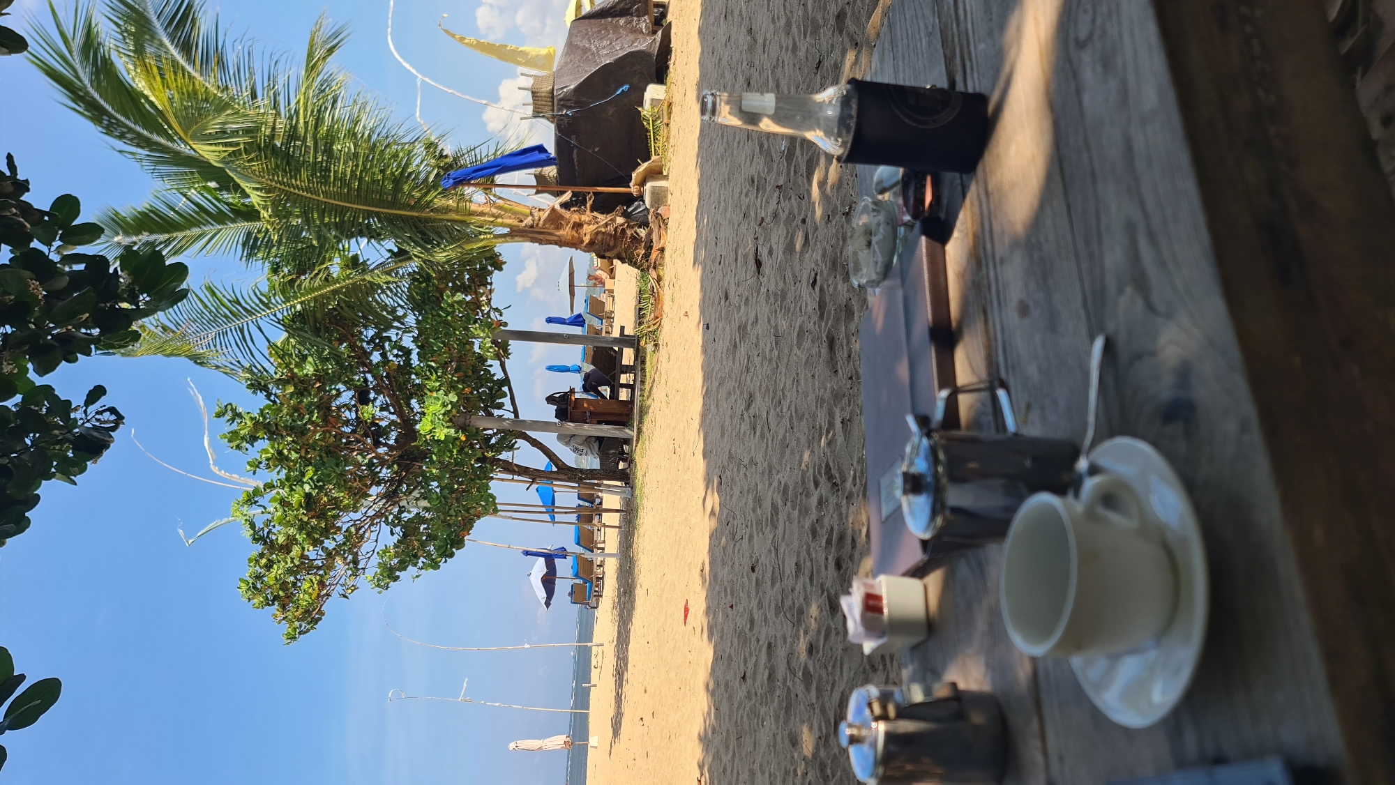 A Bali beach morning: jukung boats, kite surfers, and beach loungers