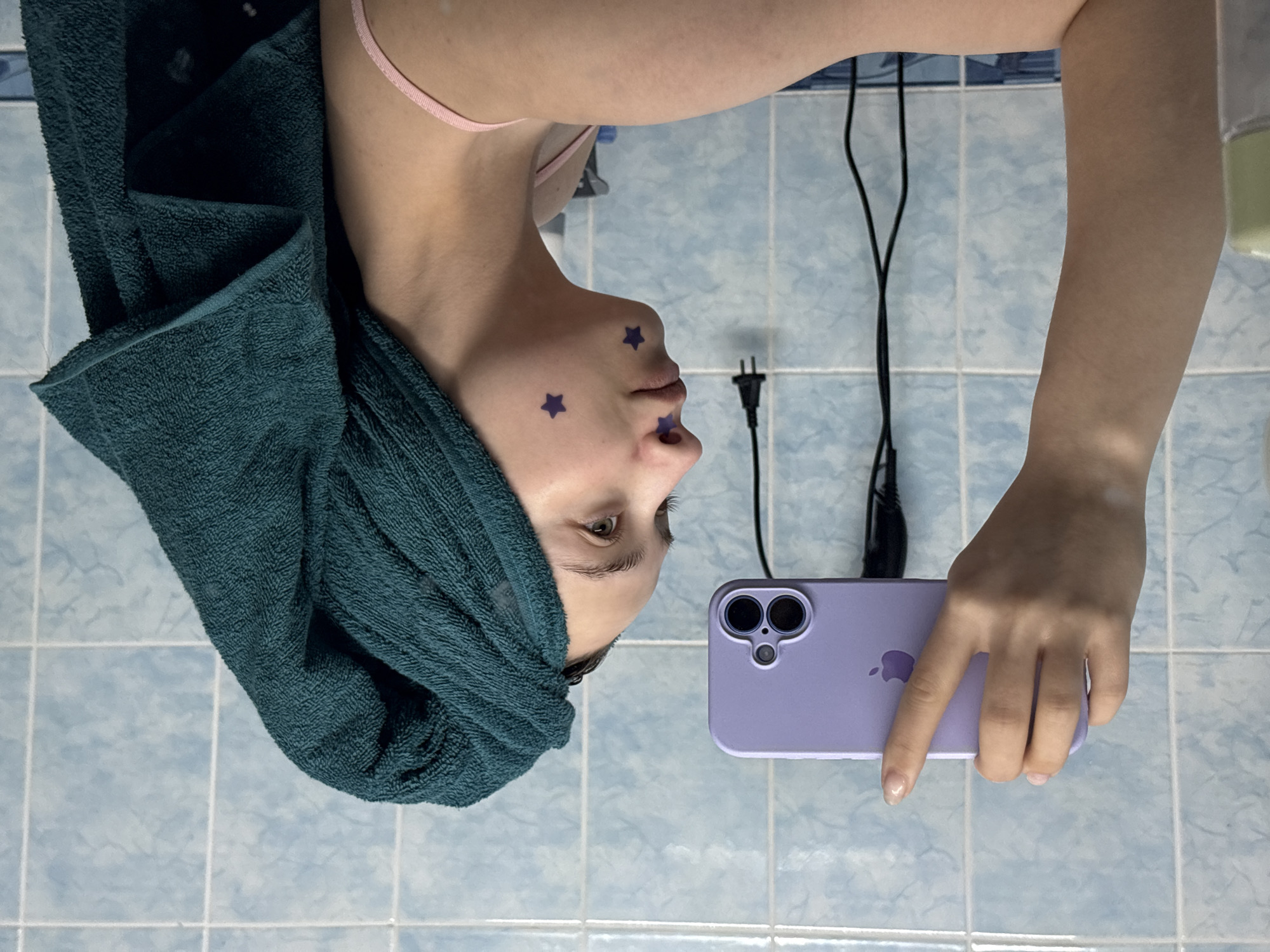 Woman takes selfies with decorative stickers in Russian bathroom
