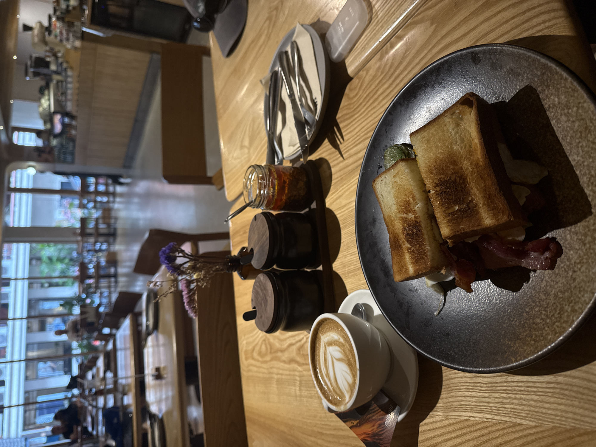 Bacon sandwich and latte at a Bangkok café table