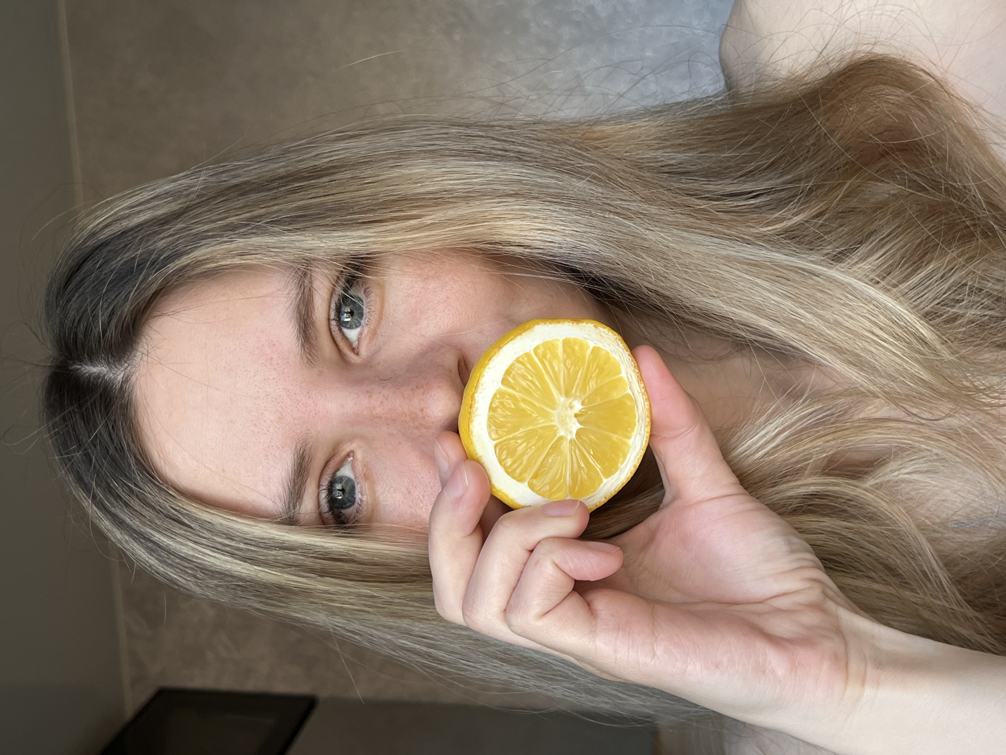 Person holds halved lemon to face in Chaikovsky, Russia