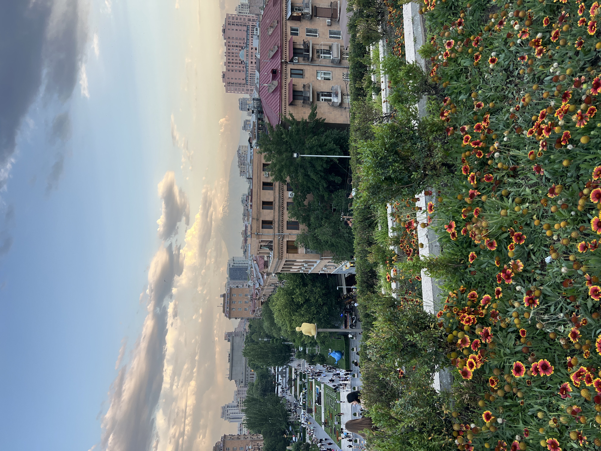 Evening at Yerevan's Cascade, flowers in bloom and city spread below