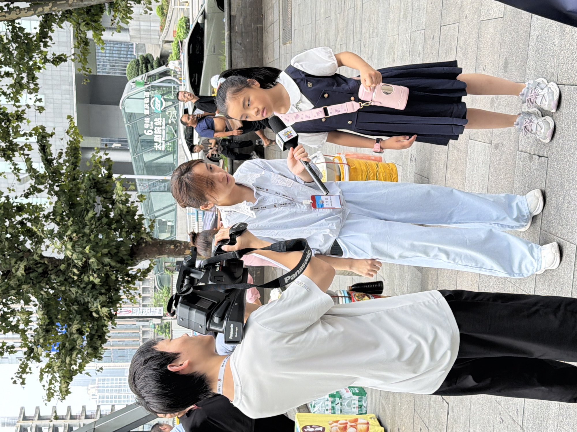 News crew and street vendors near a Chongqing subway entrance