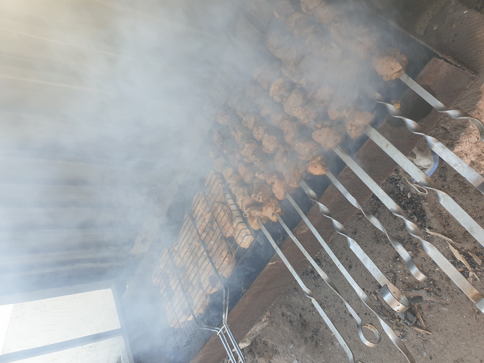 Outdoor coal grilling with skewers in Kuryk, Kazakhstan