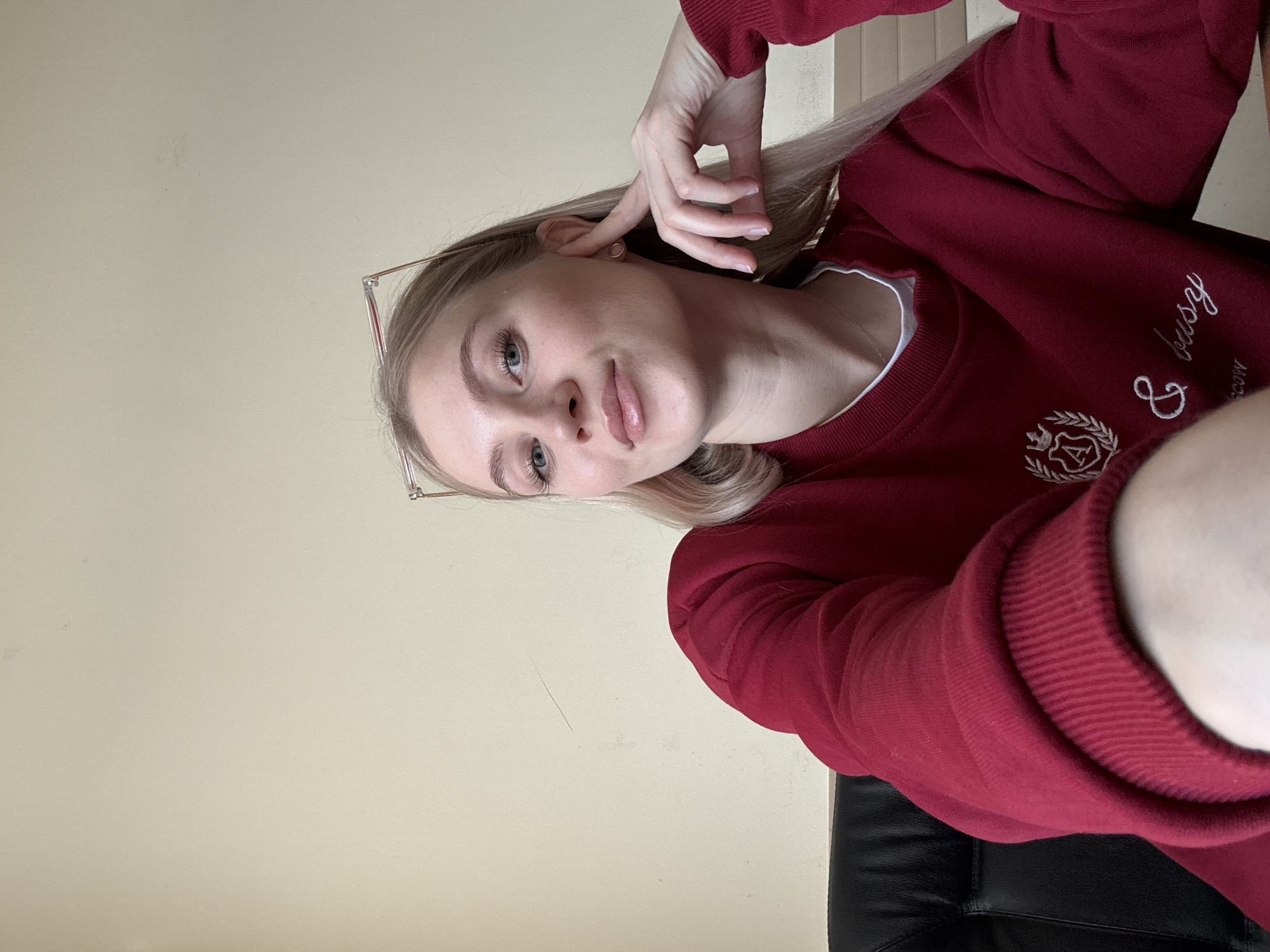 Woman takes early morning selfie in maroon sweatshirt
