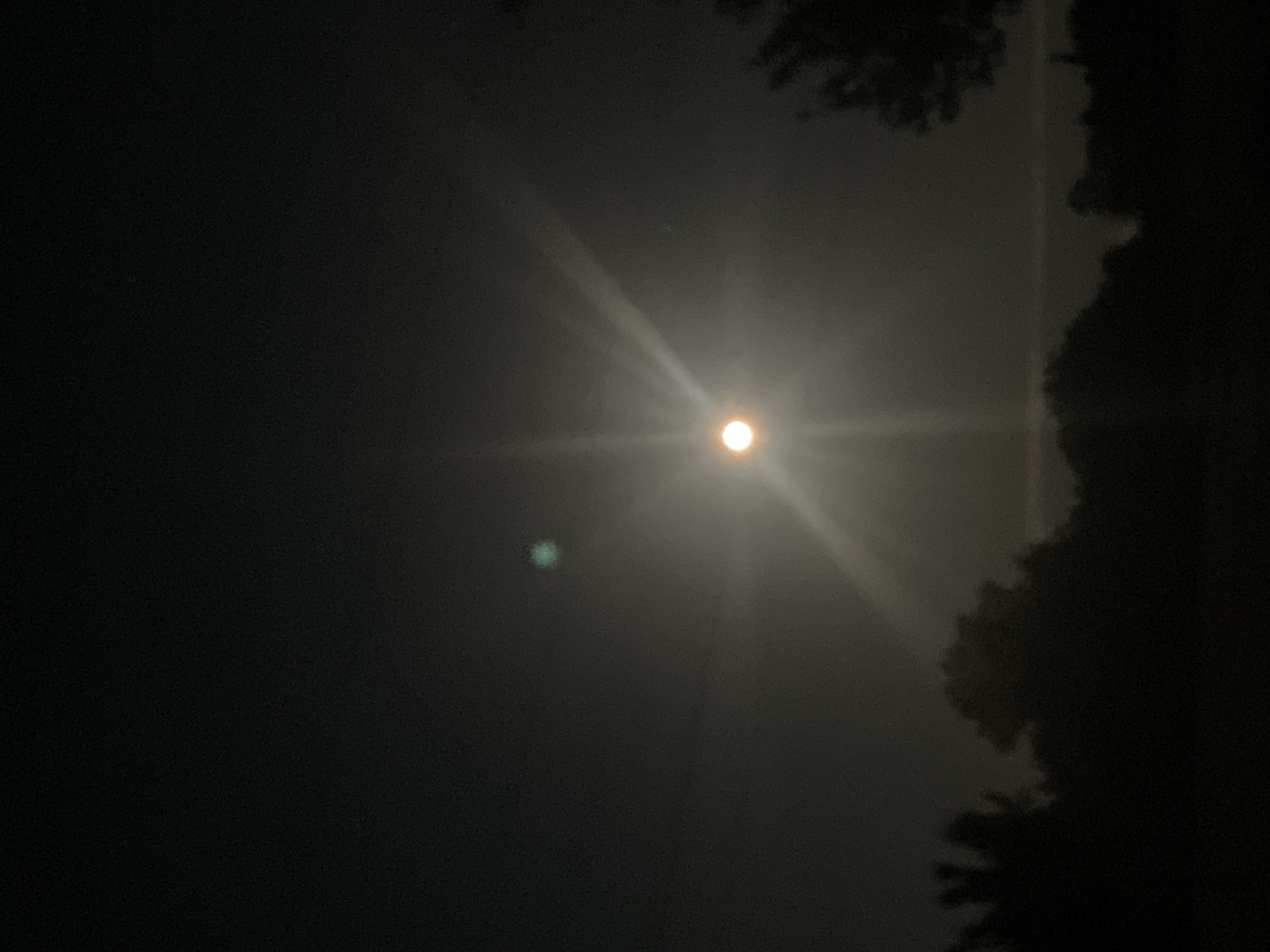 Bright nighttime light source illuminates unknown location sky