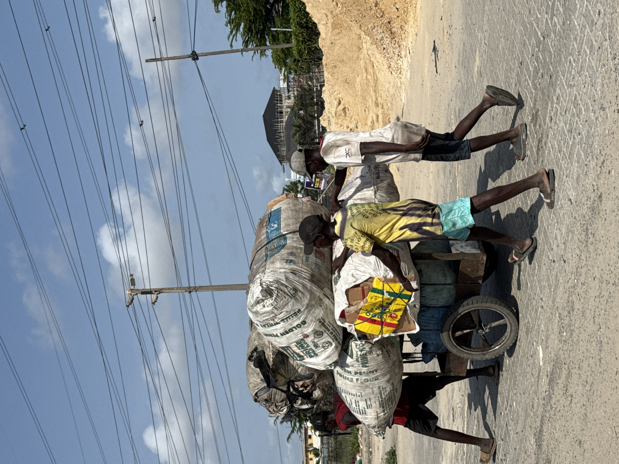 Men transport flour sacks by cart in Lekki