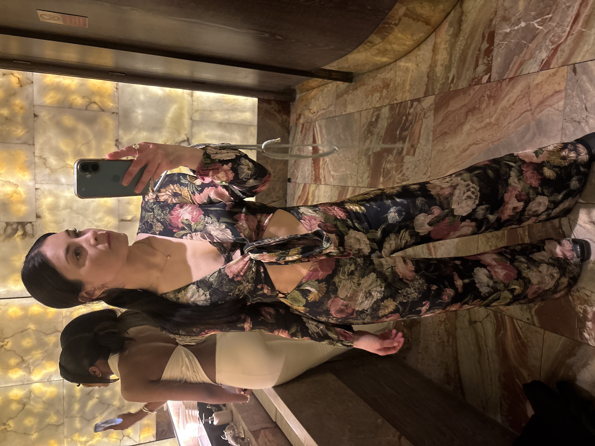 Women photograph themselves in London bathroom mirror