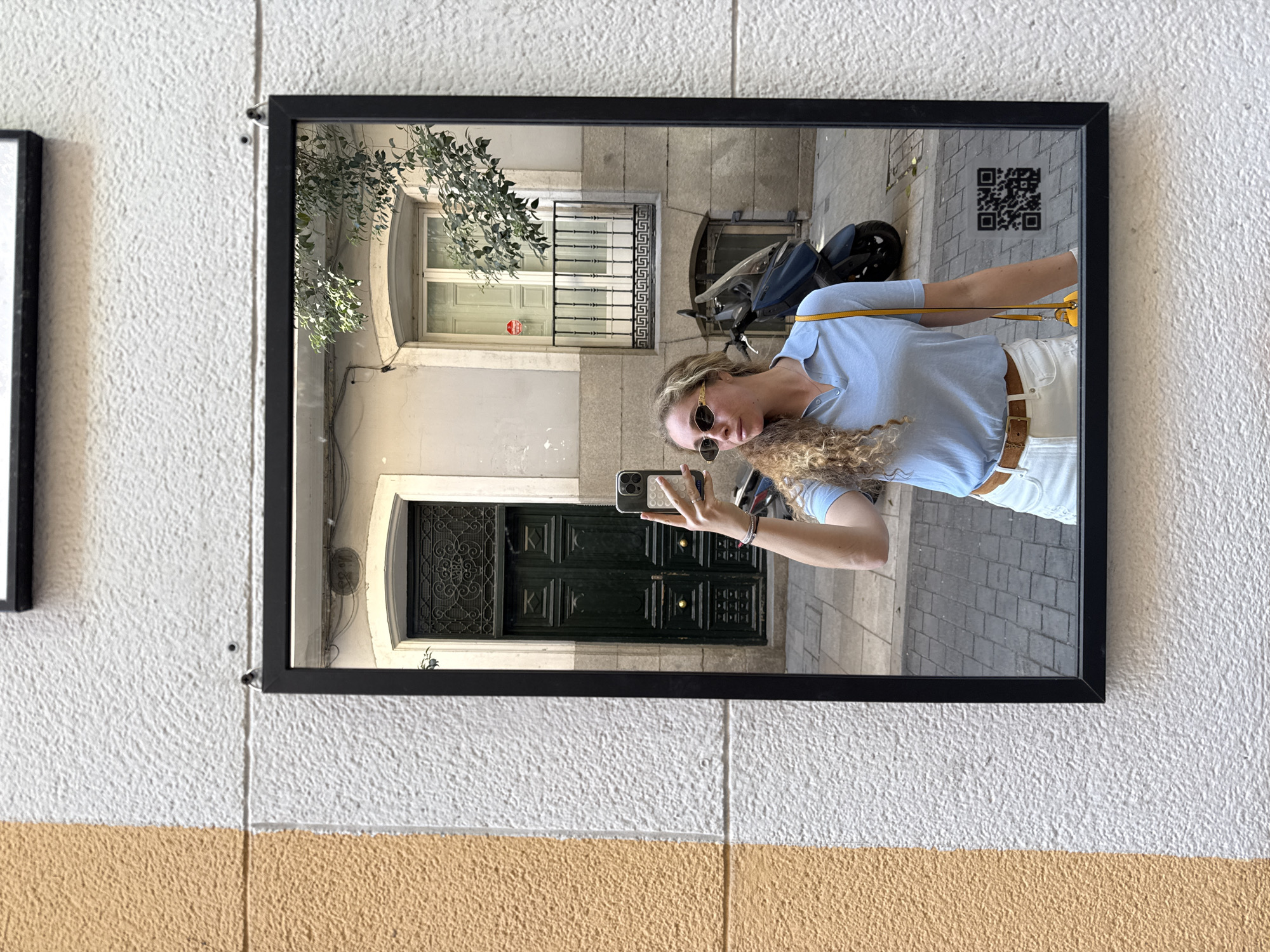 Woman photographed through street mirror reflection in Madrid