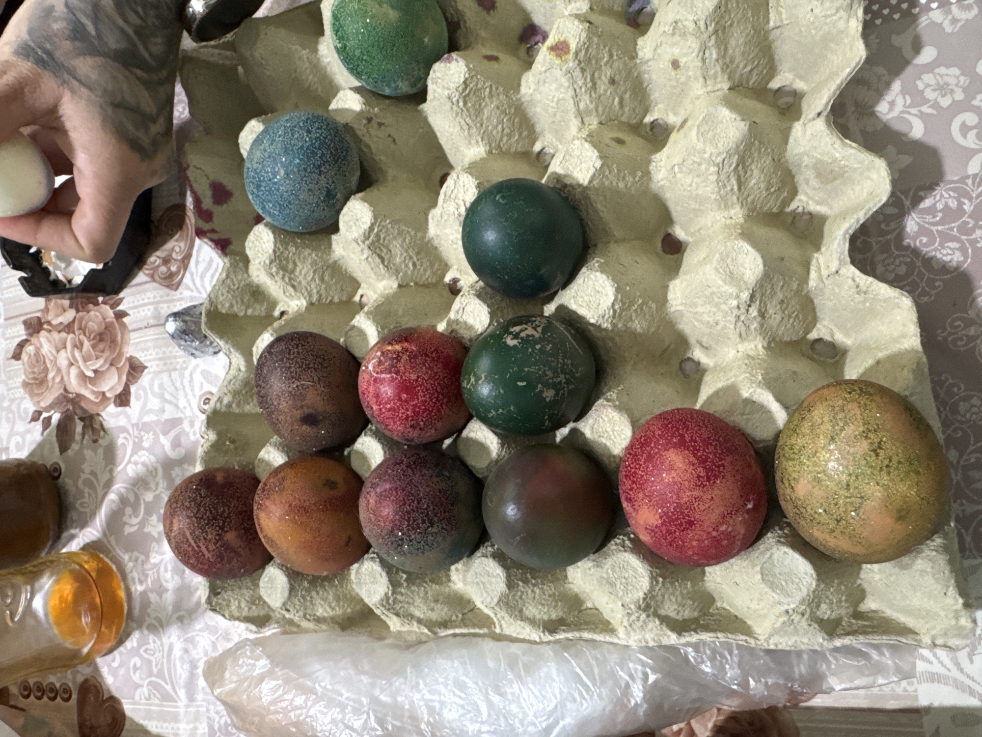 Easter eggs arranged in carton on floral tablecloth