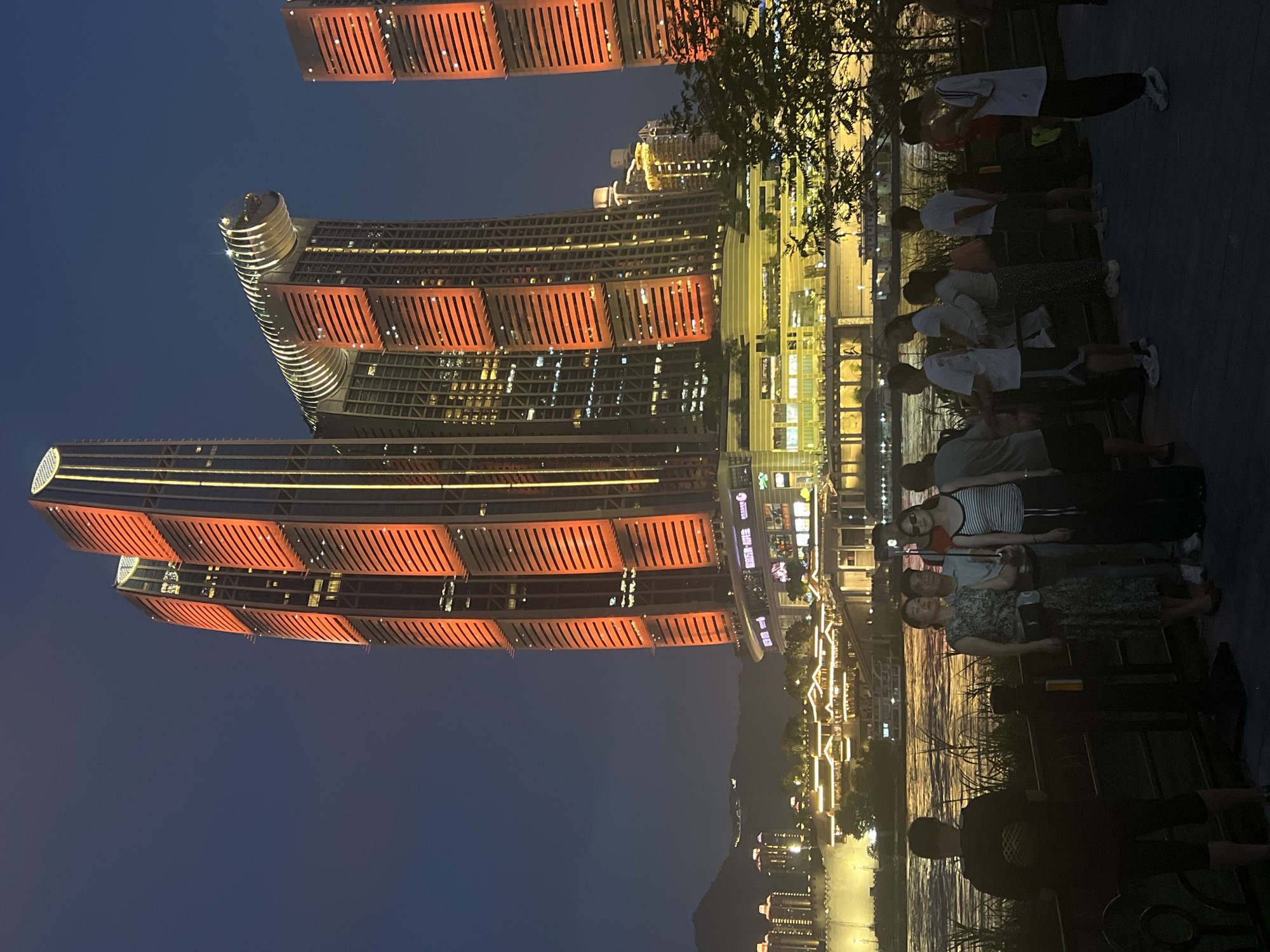 Chongqing riverfront glowing after dark across multiple districts
