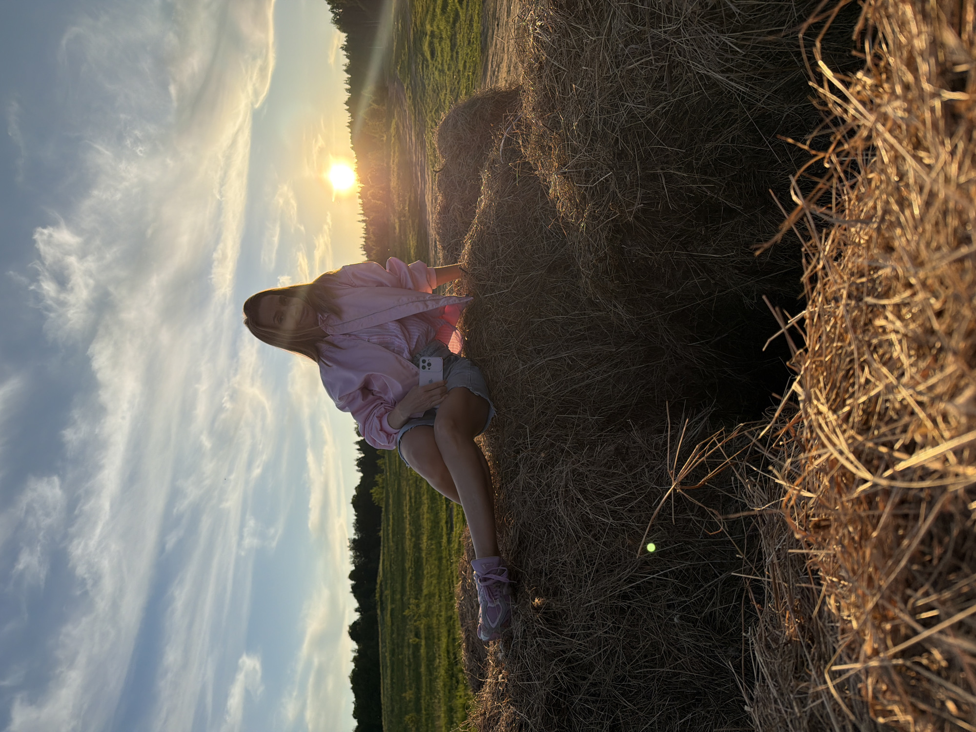 Person sits on hay bale during sunset in Mars, Russia