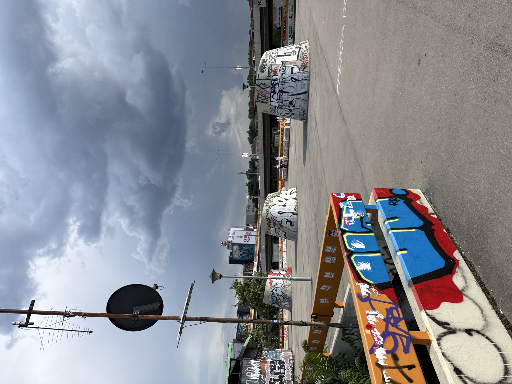 Brutalist Belgrade under storm clouds, graffiti and concrete.