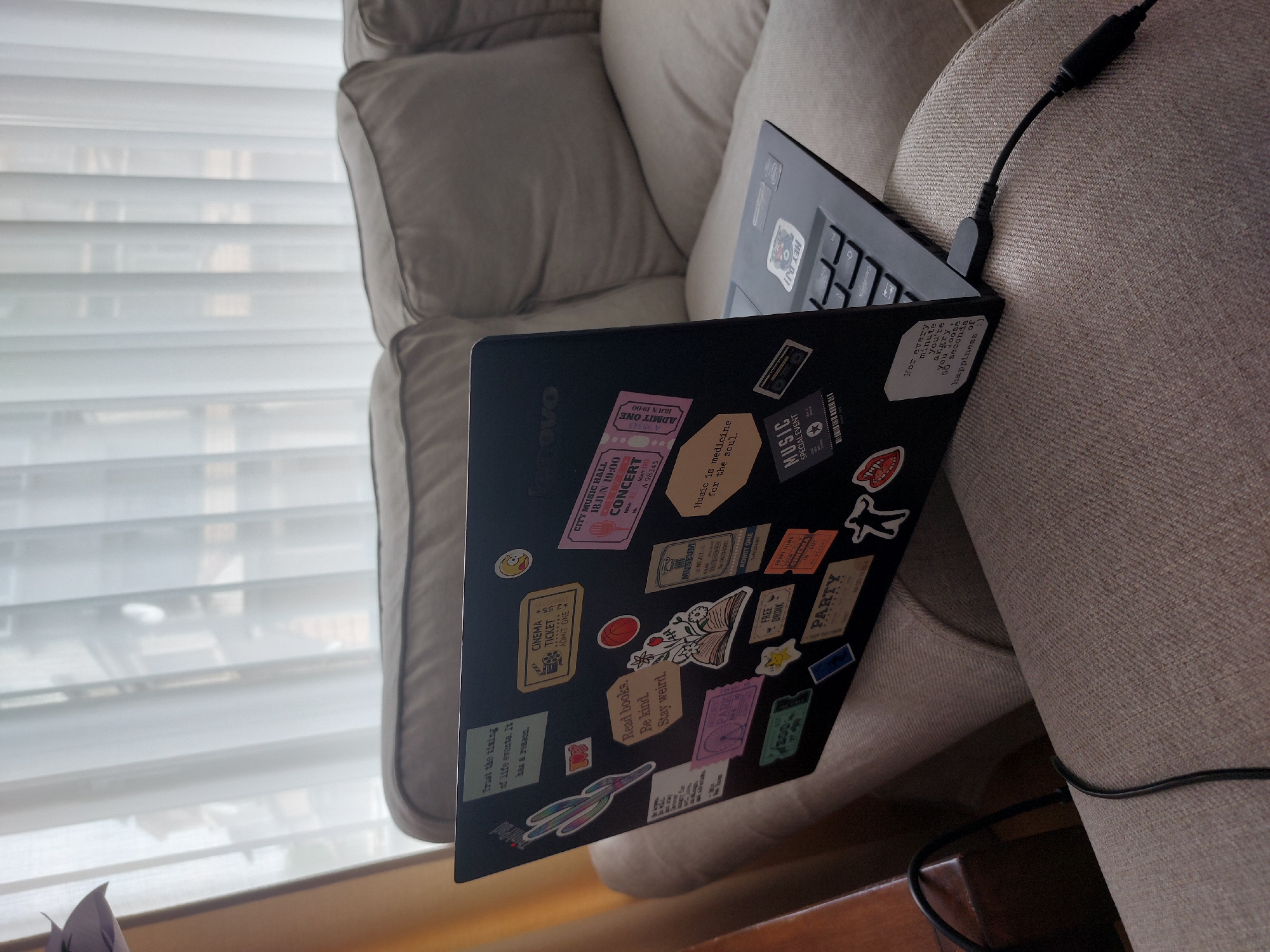 Sticker-covered laptop observed on couch in Plovdiv, Bulgaria