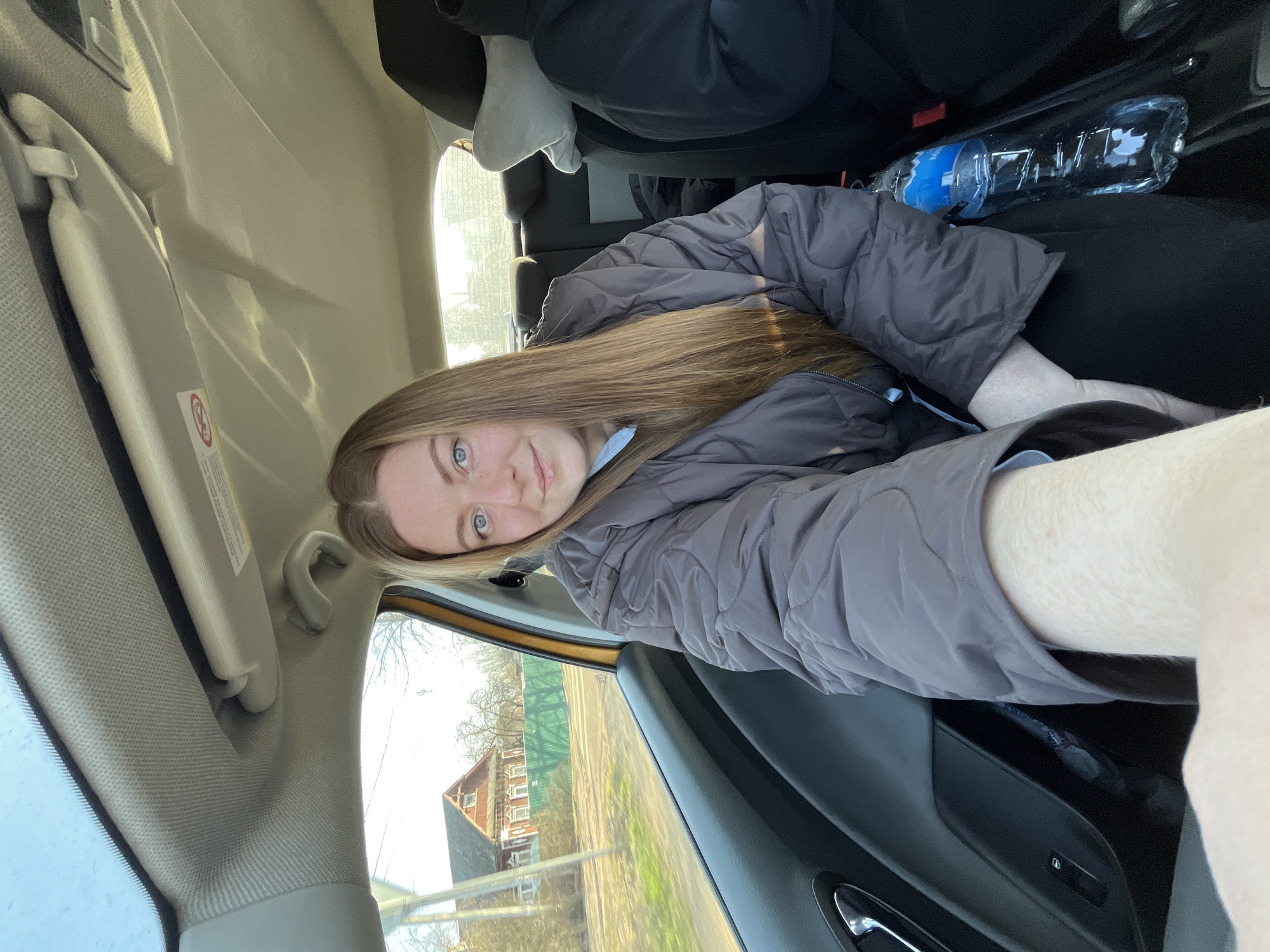 Woman sits in car passenger seat in Maksimkovo