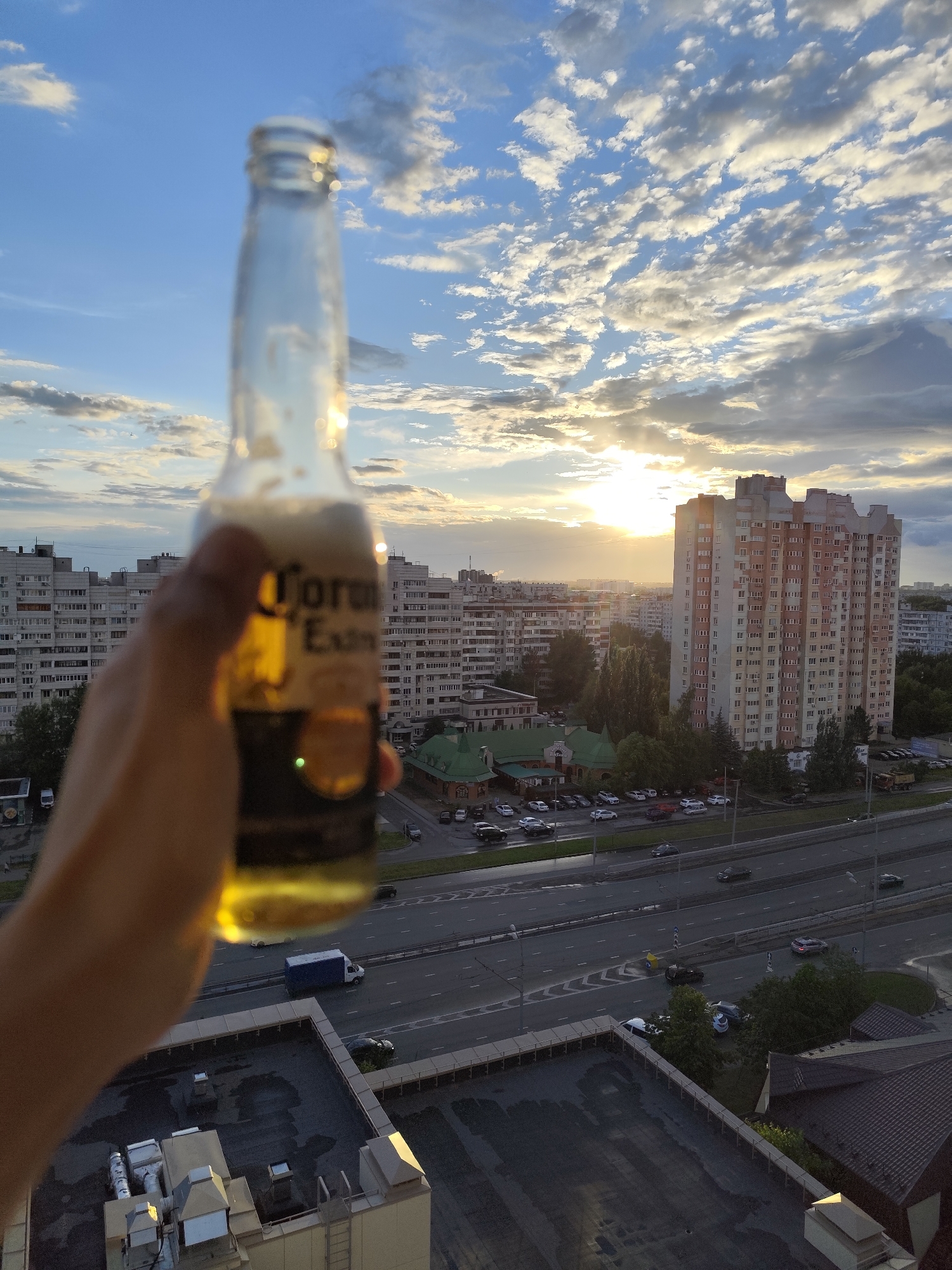 Corona in hand, Kazan skyline glowing at sunset