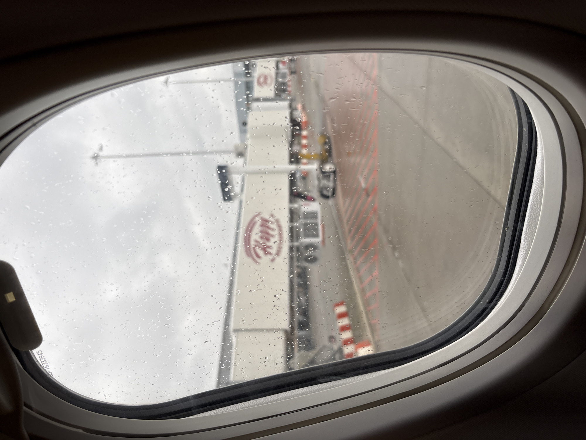 Rainy airport view captured through airplane window in Sofia