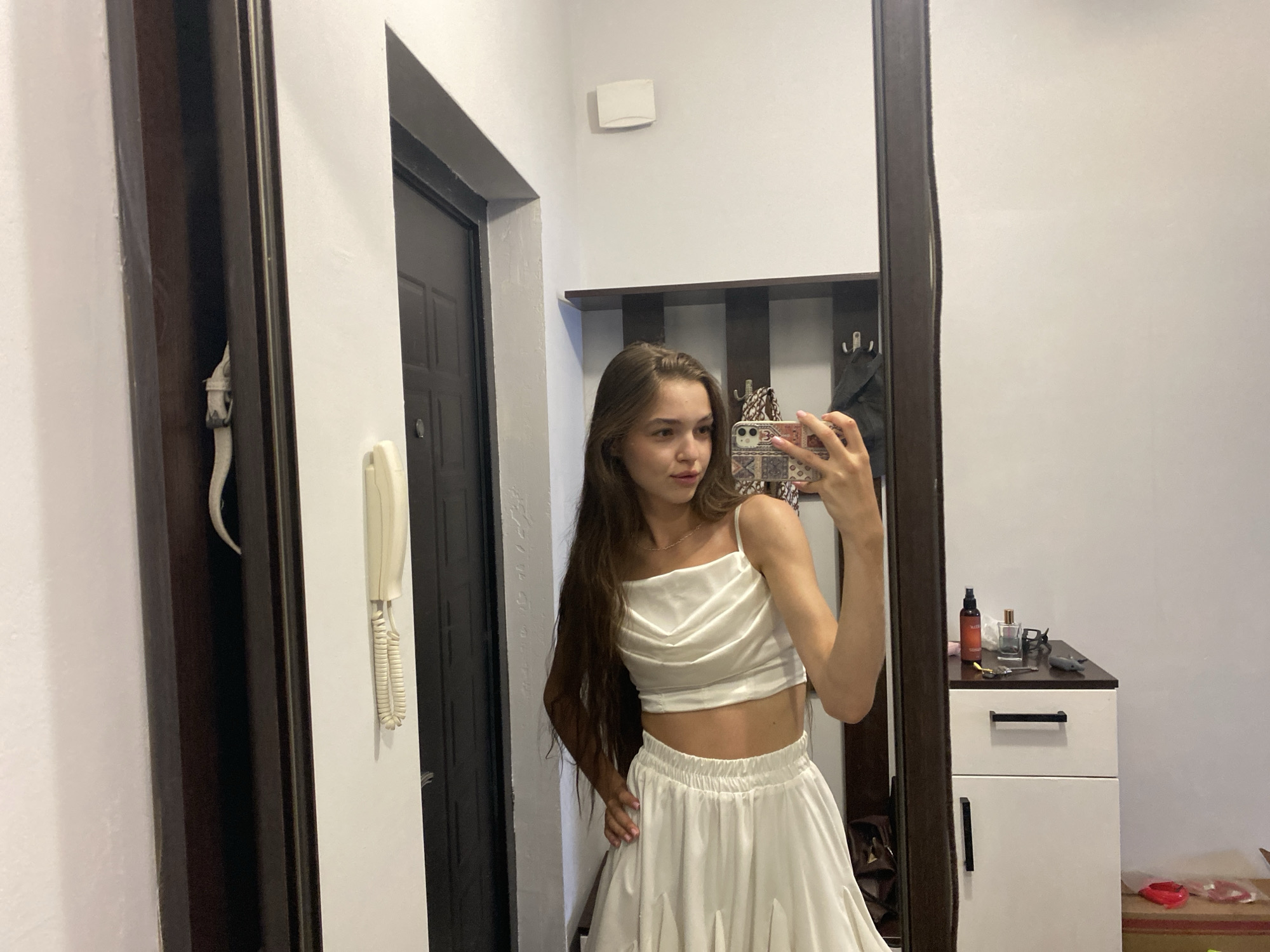 Indoor selfie session mixing outfit looks and skincare