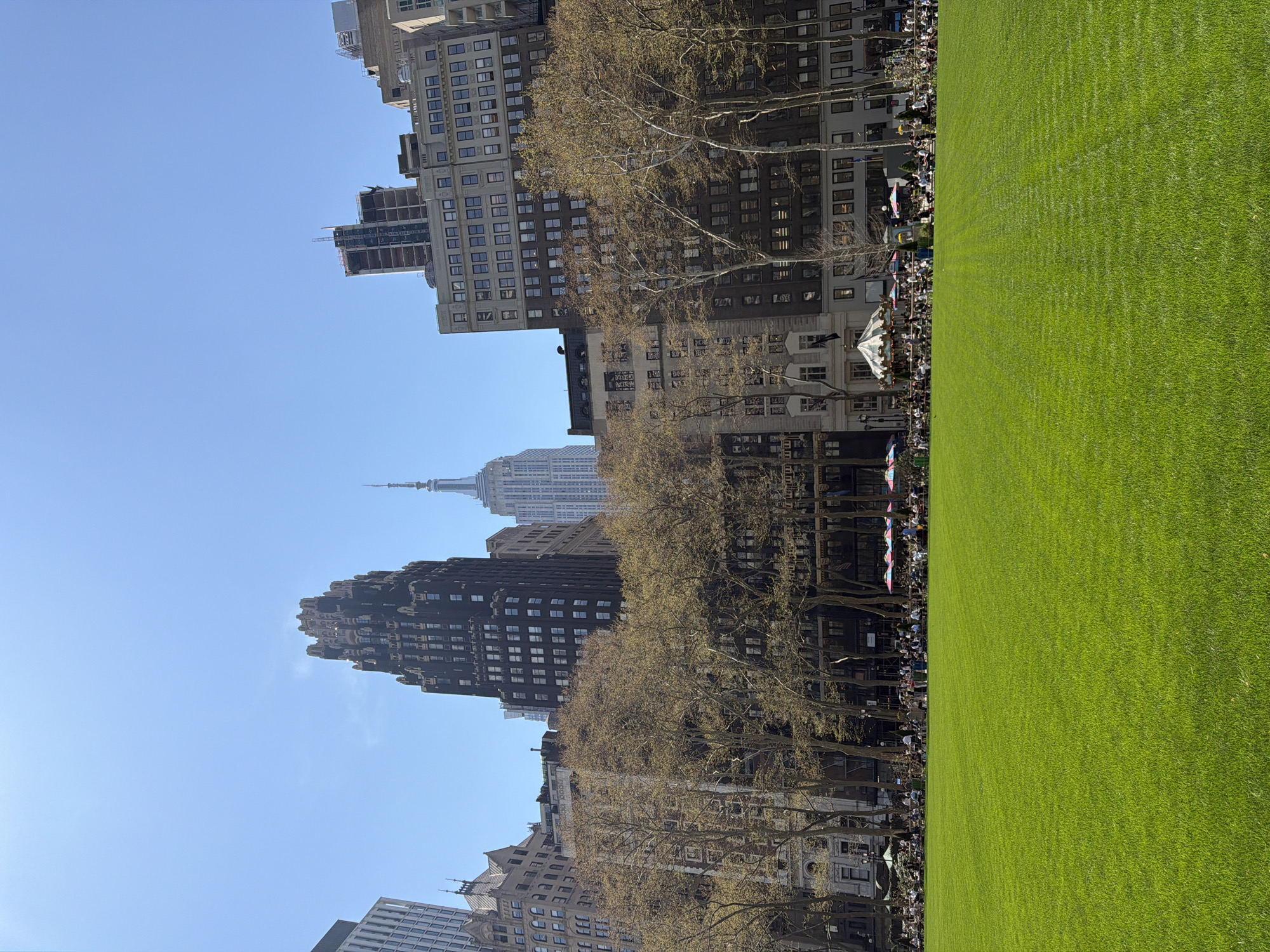 Afternoon crowd gathers at Bryant Park beneath Empire State Building