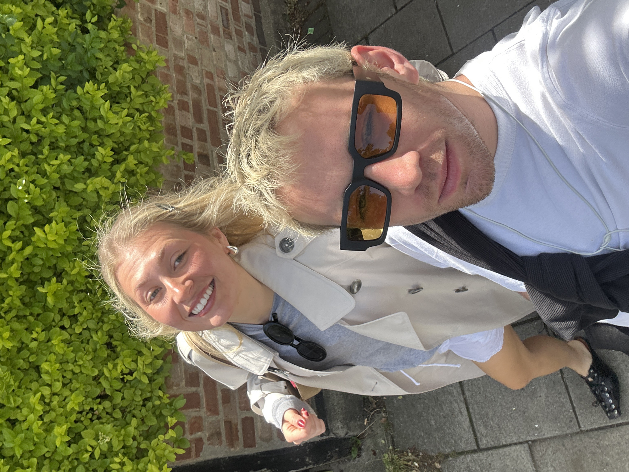 Couple taking selfies on London sidewalk