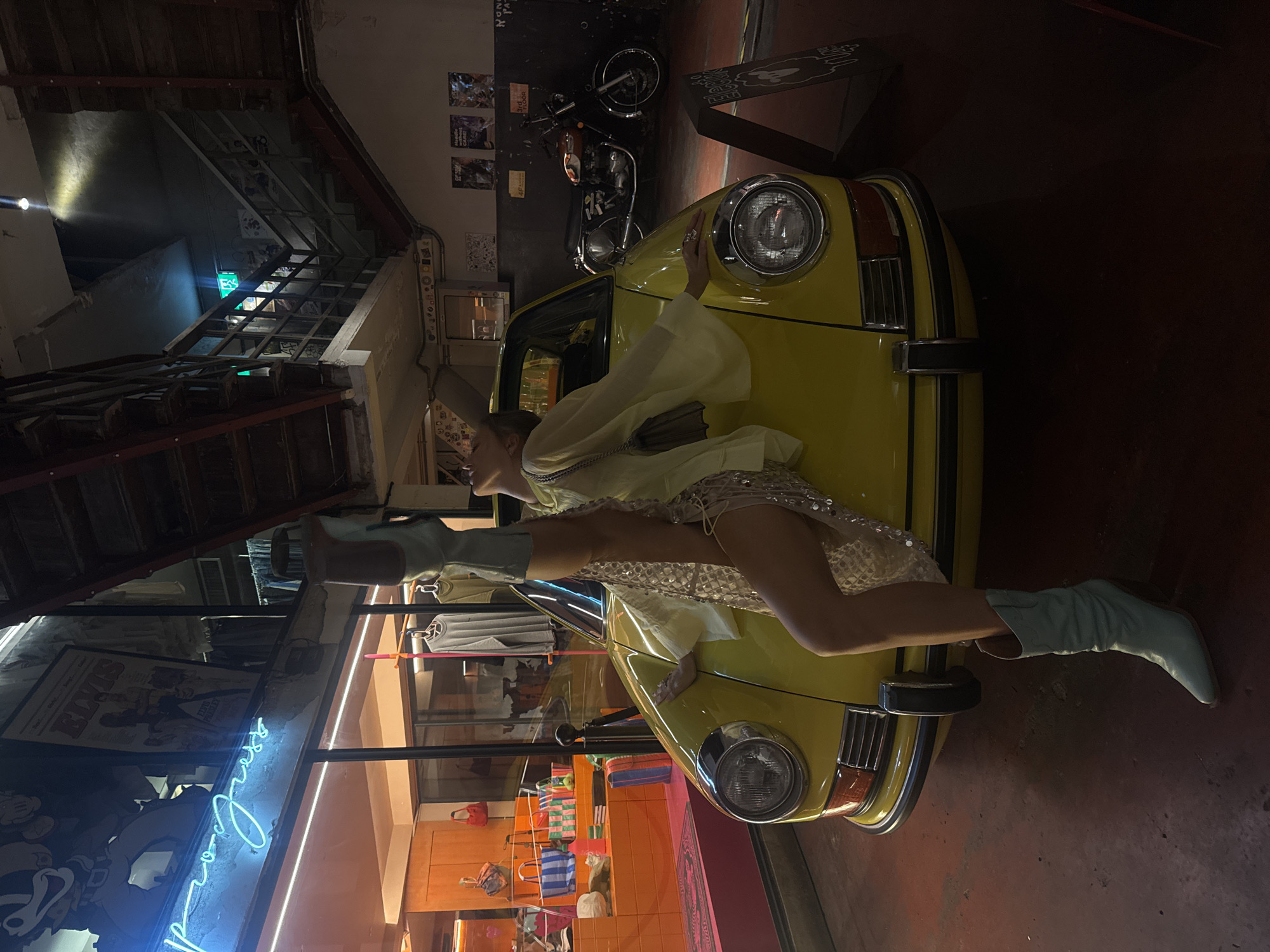 Bold fashion pose on a vintage yellow car in Bangkok.