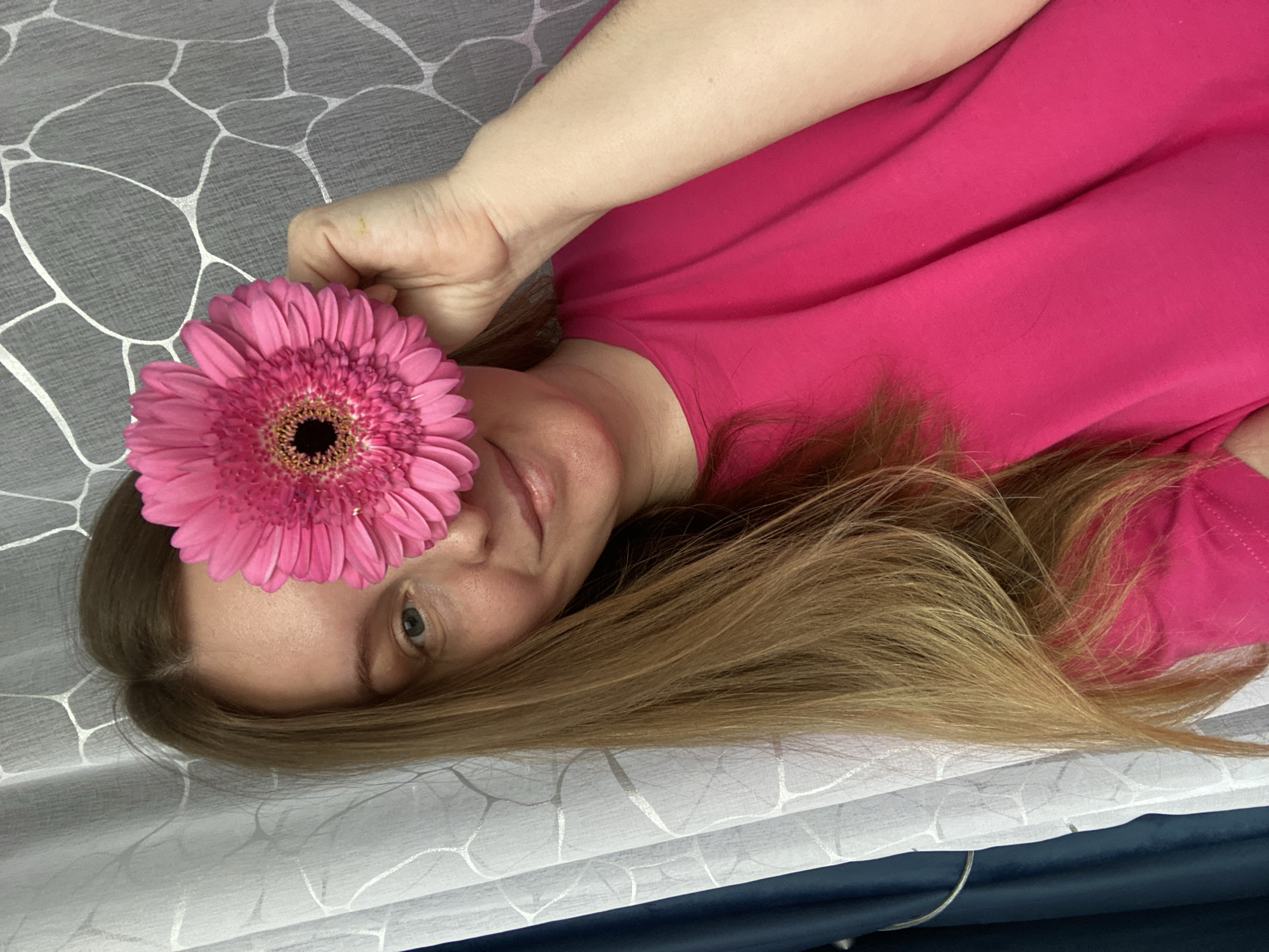 Woman poses with pink gerbera daisy in Noviy photo session