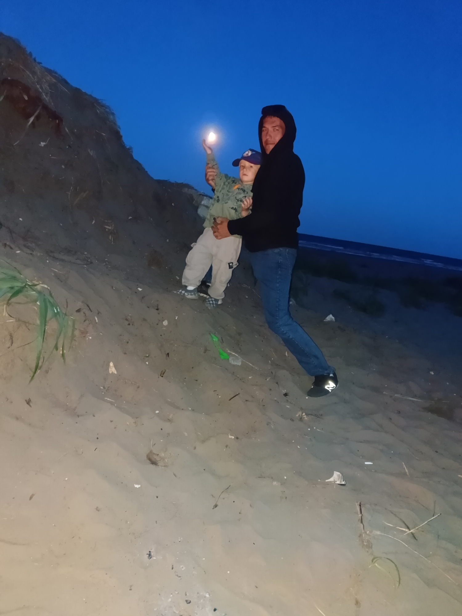 Dusk hangout on a sandy beach with fire and kids