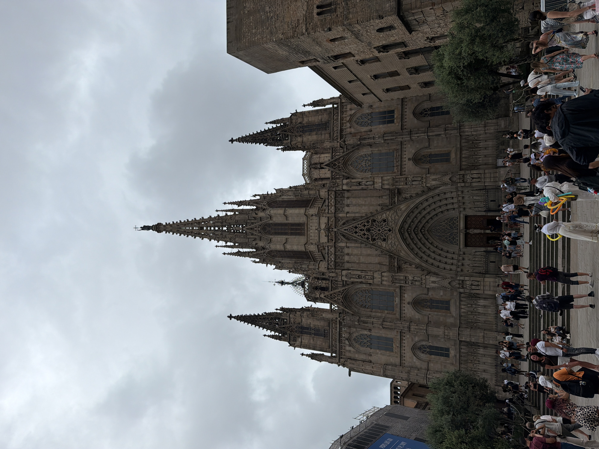 Tourist explores Barcelona Cathedral and Gothic Quarter on overcast afternoon