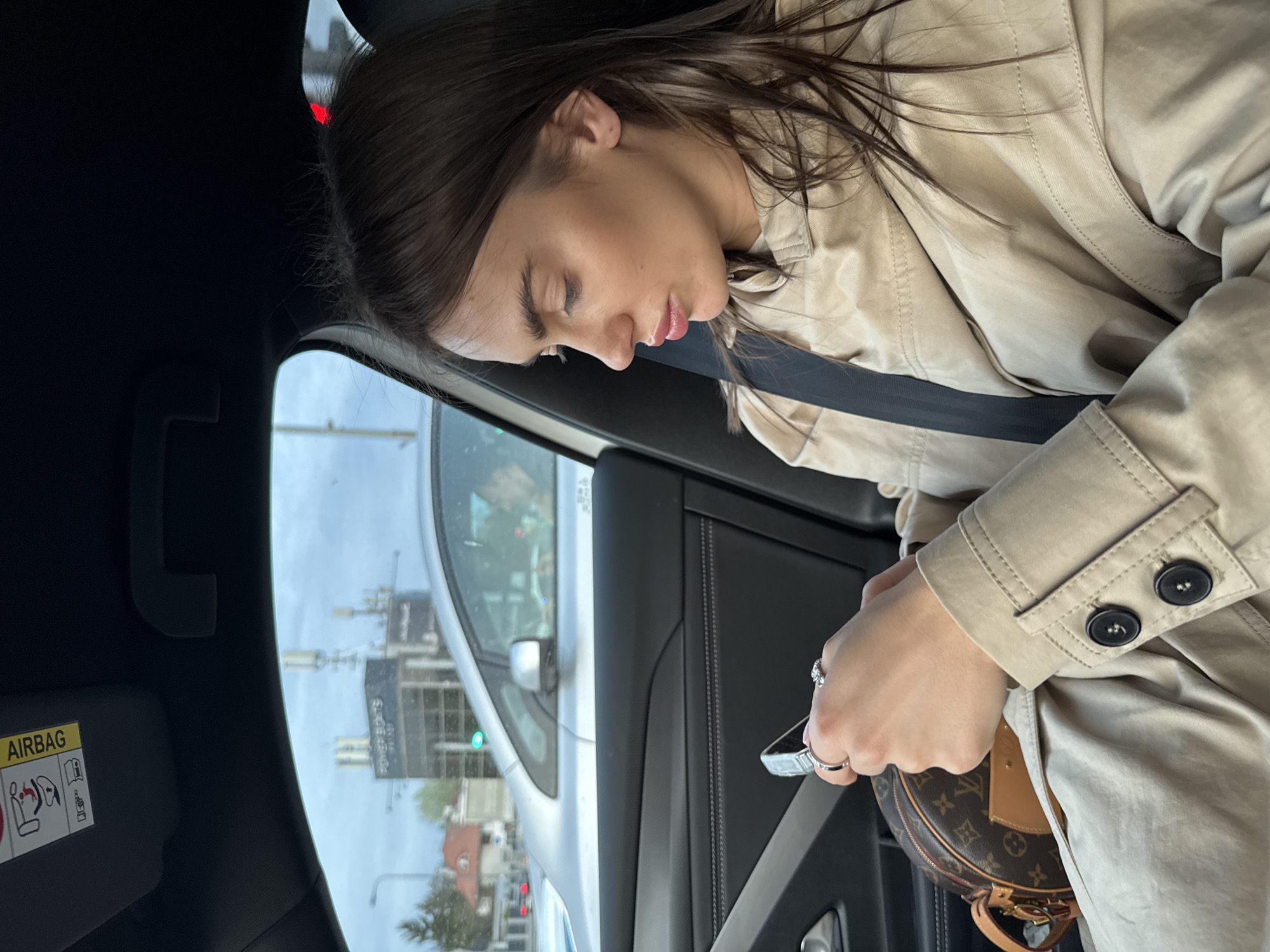 Woman in trench coat observed in car passenger seat, Warsaw