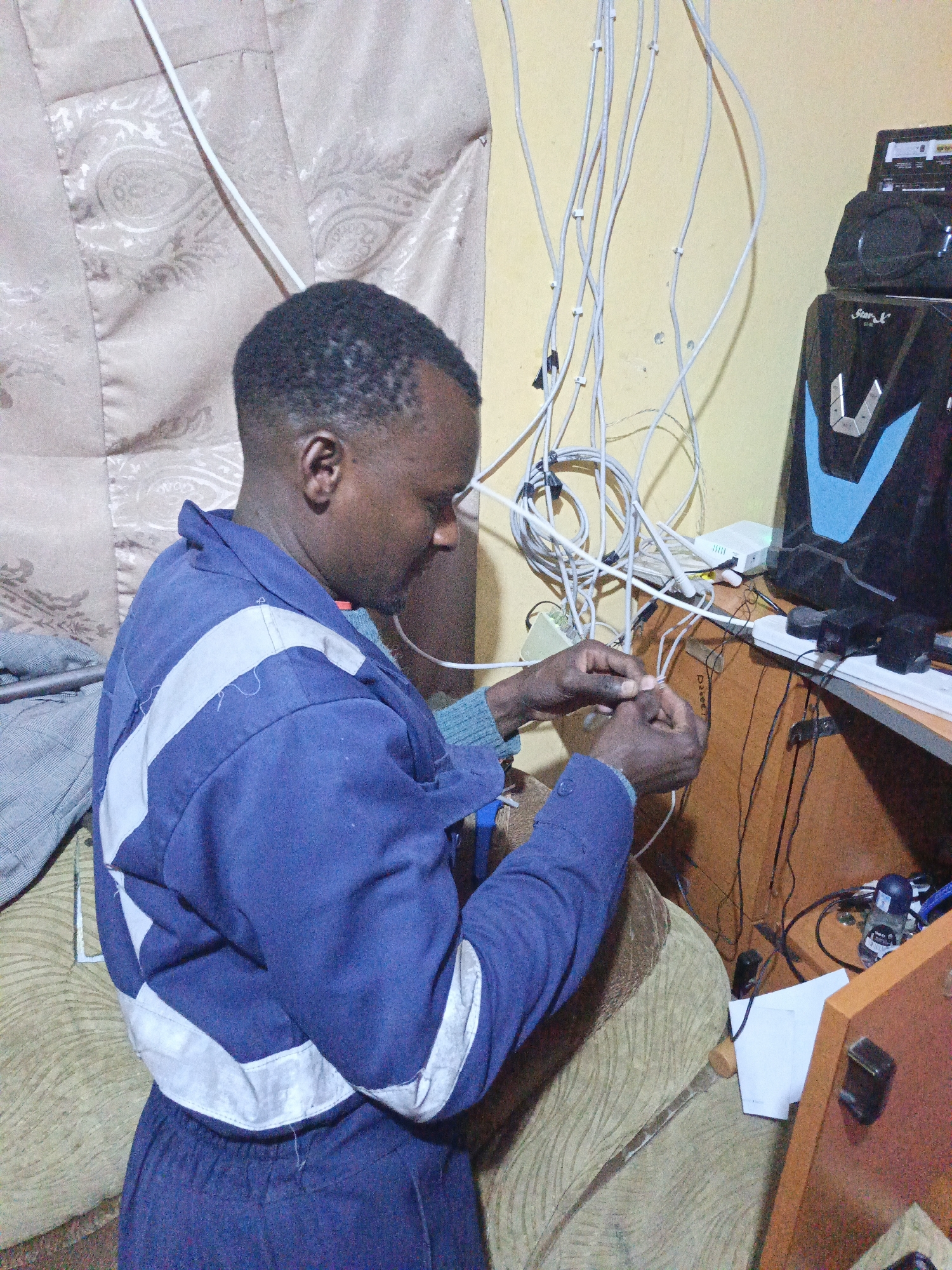 Technician performs electrical work on computer equipment in Nairobi