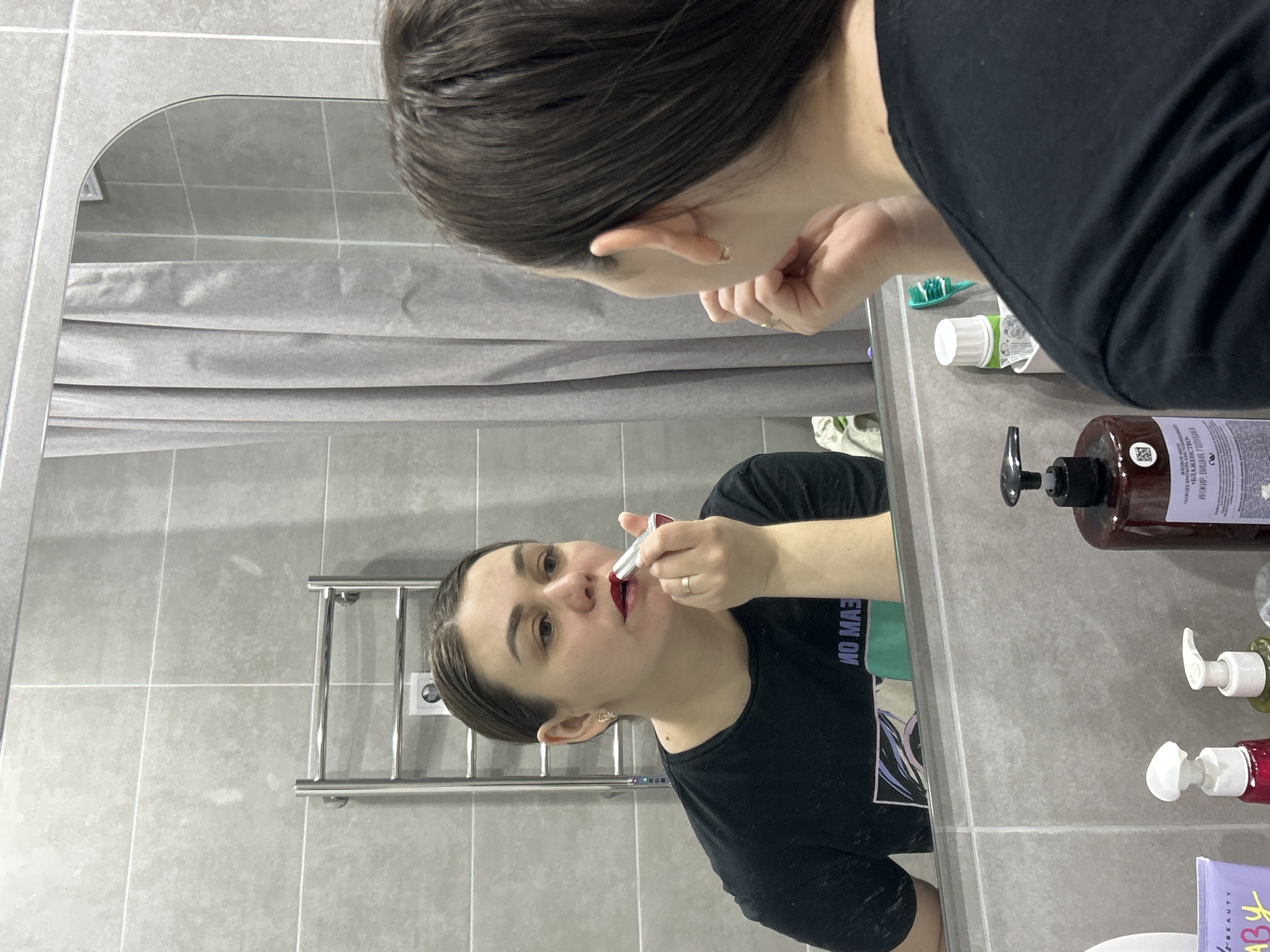 Woman applies makeup in Chaikovsky bathroom, shows manicured nails
