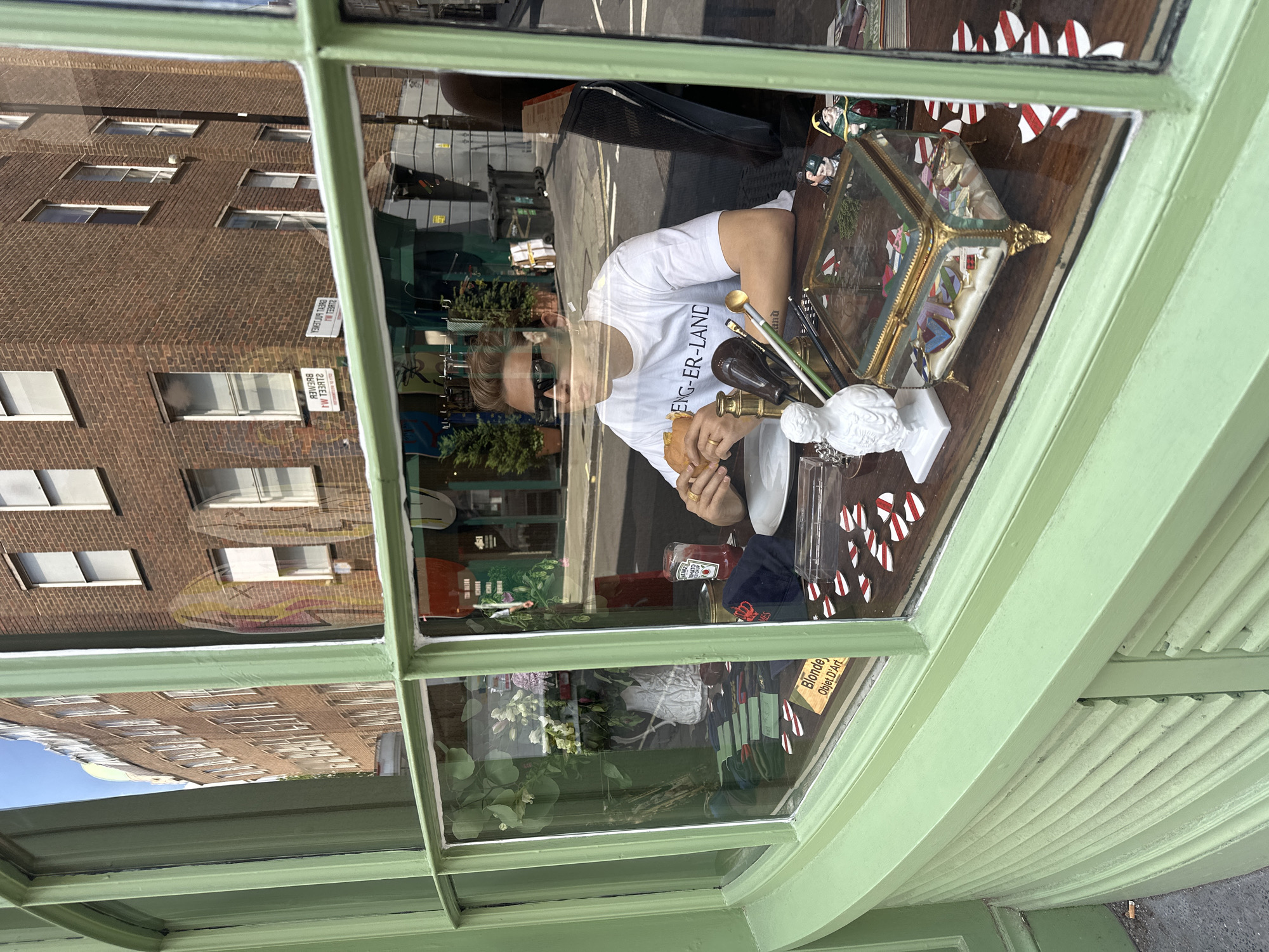 Hamburger in hand at a London shop counter