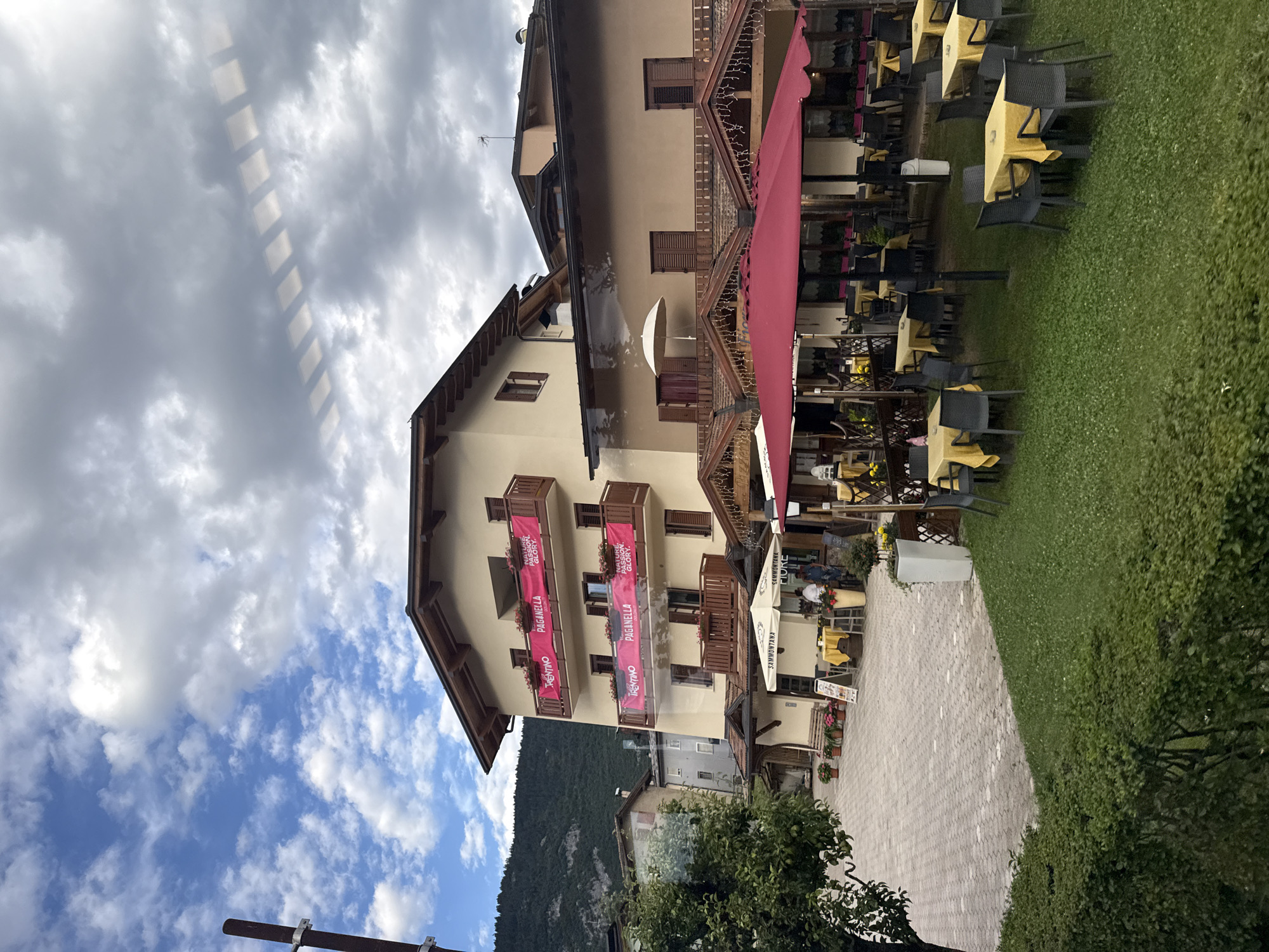 Alpine street scene in Cavedago with dining terrace and traditional facades