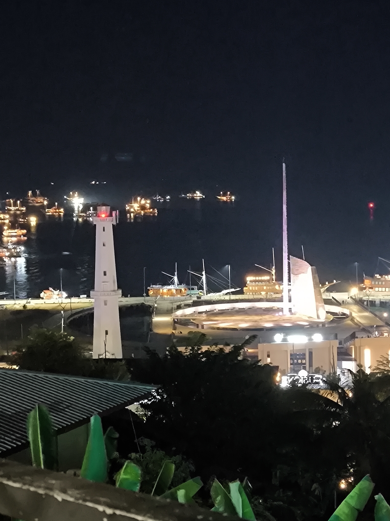 Labuan Bajo harbor and lighthouse lit up at night