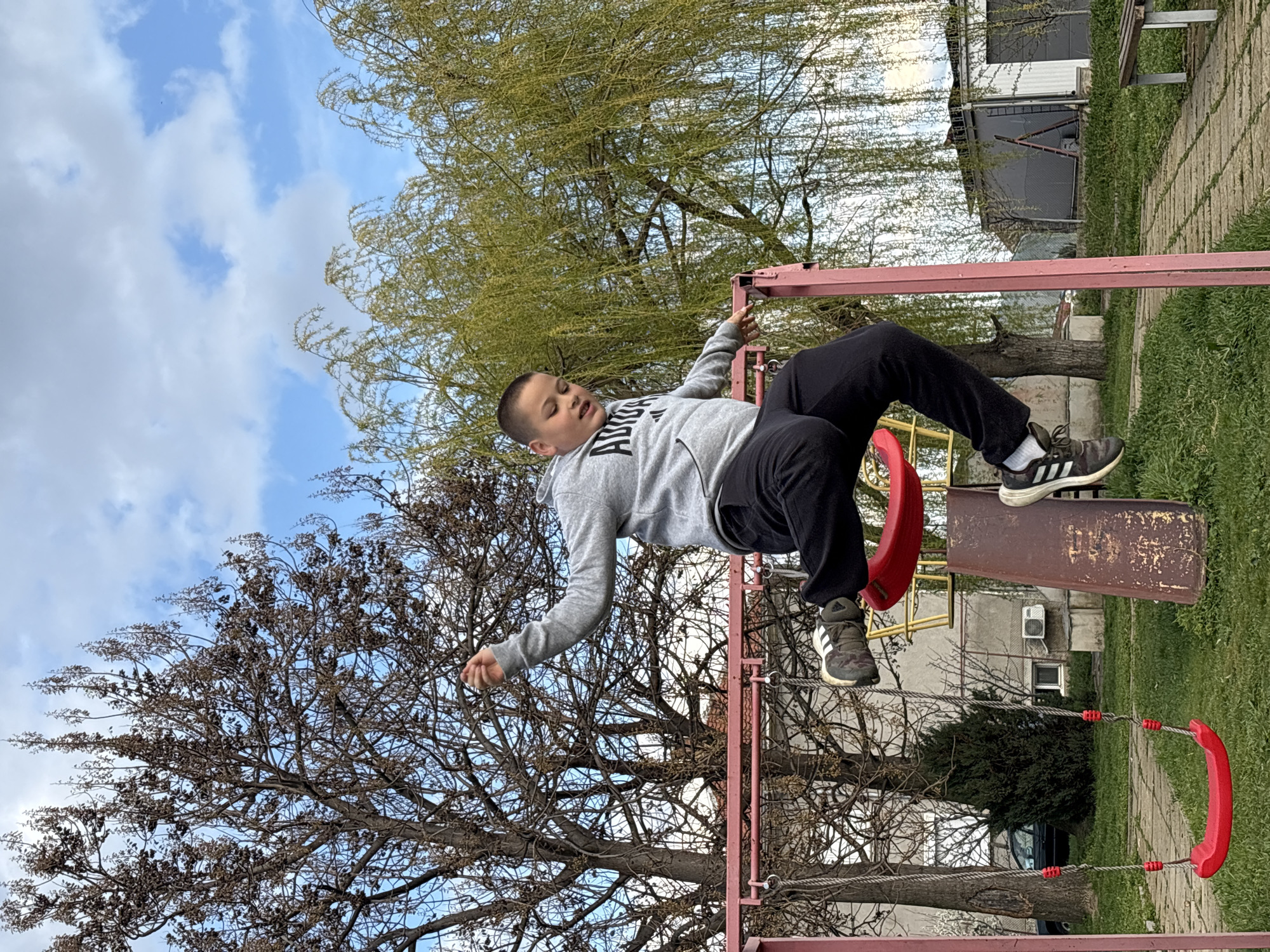 Young person rests on swing set in park area