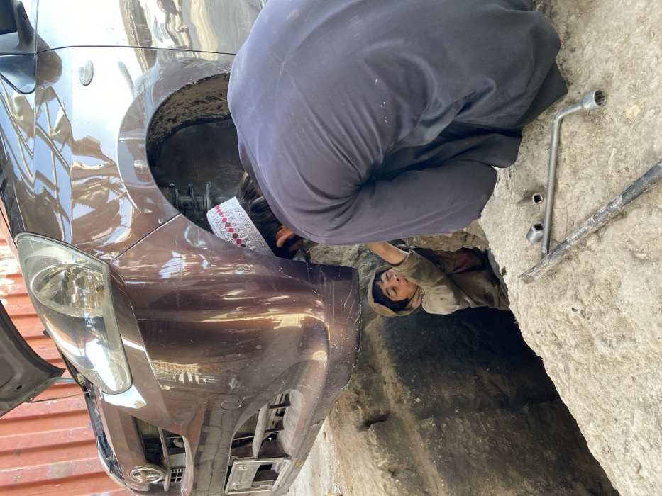 Auto repair yard activity documented in Kandahar morning hours