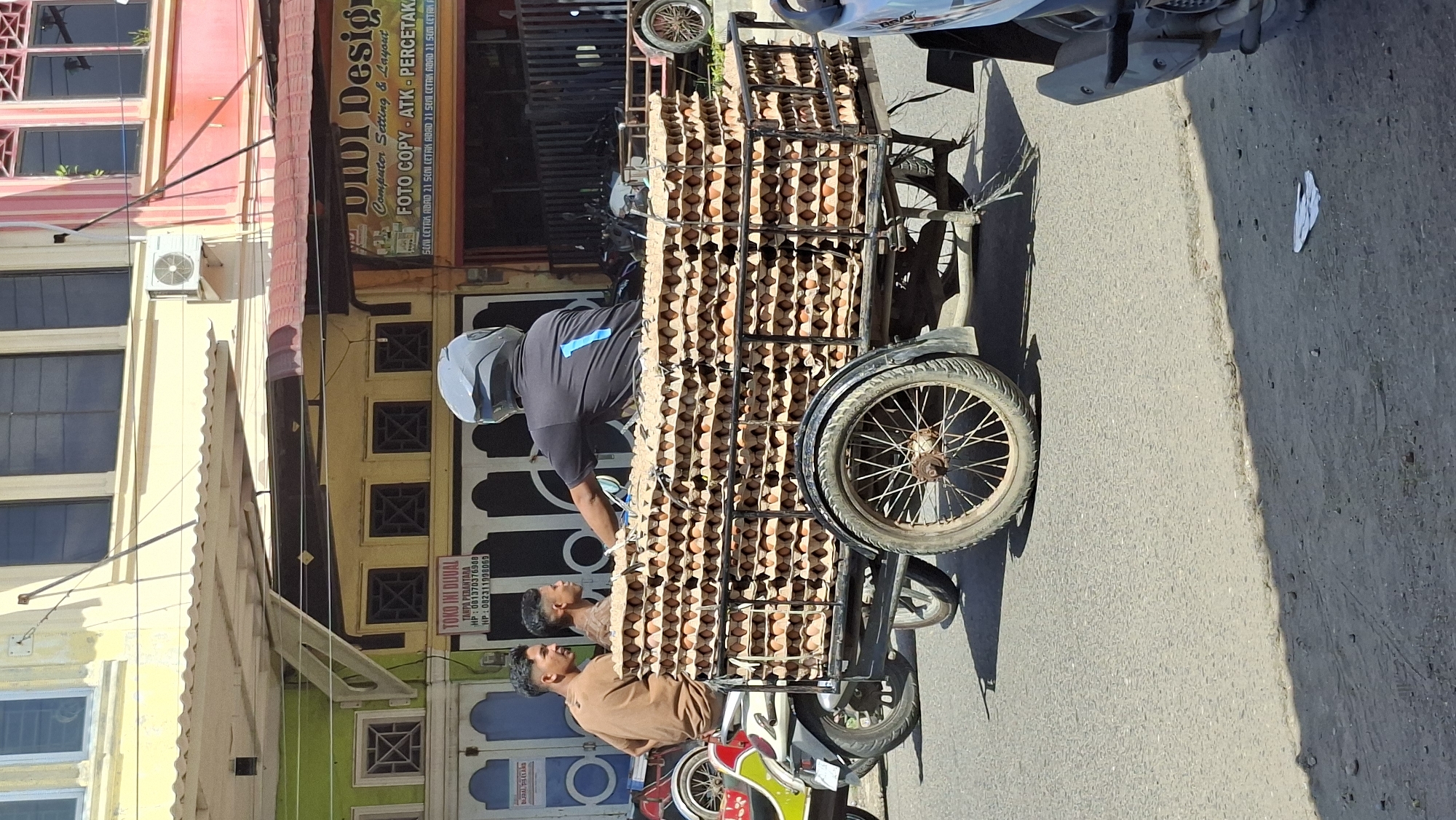 Morning street life and commerce moving through Lhokseumawe